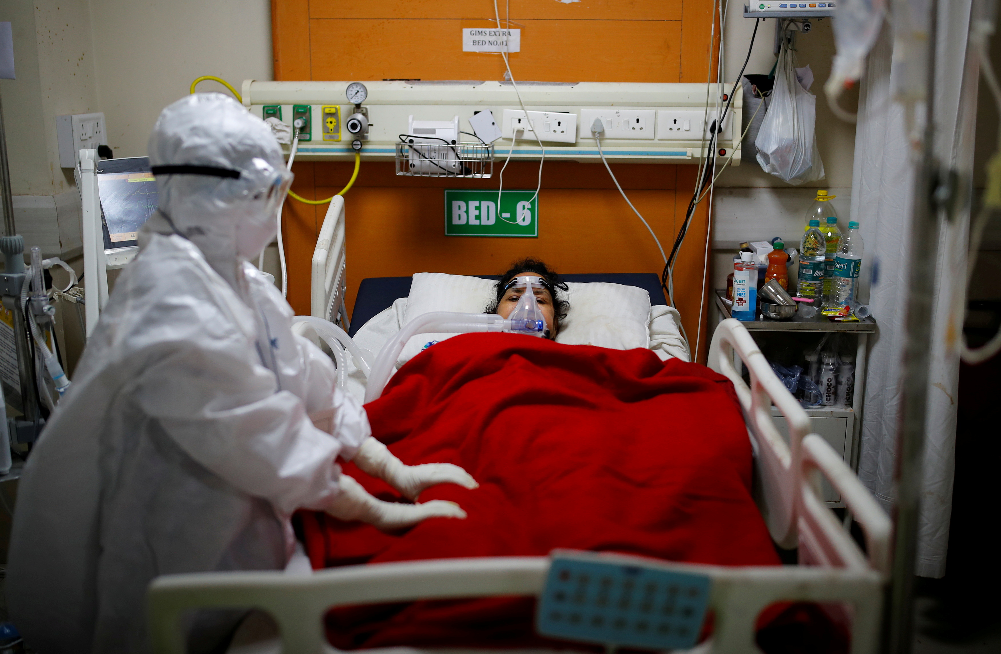 A medical worker takes care of a patient suffering from the coronavirus disease (COVID-19), inside the Intensive Care Unit (ICU) ward at the Government Institute of Medical Sciences (GIMS) hospital, in Greater Noida on the outskirts of New Delhi, India, May 21, 2021. REUTERS/Adnan Abidi/File Photo