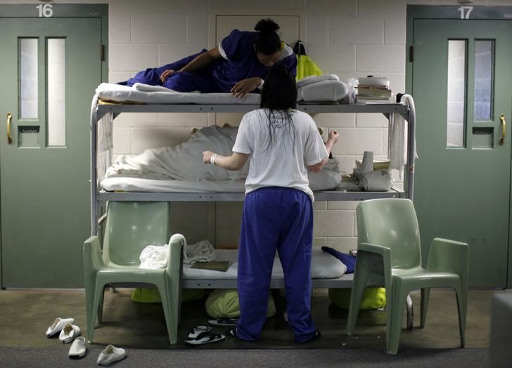 Women chat as they lie in beds placed in the communal area outside cells, due to overcrowding at the Los Angeles County Women's jail in Lynwood