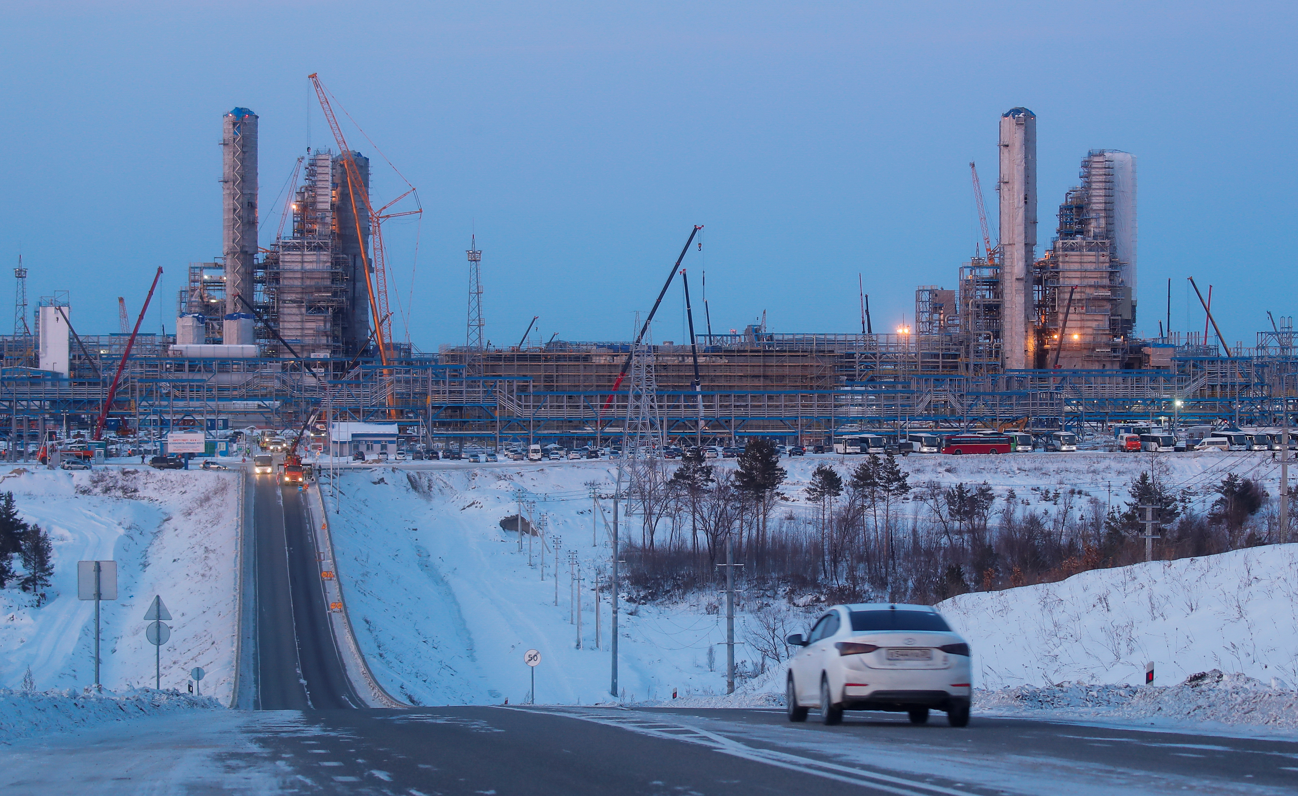 A car drives in front of facilities of Amur gas processing plant under construction, part of Gazprom's Power Of Siberia project outside the far eastern town of Svobodny, in Amur region, Russia November 29, 2019.  REUTERS/Maxim Shemetov.