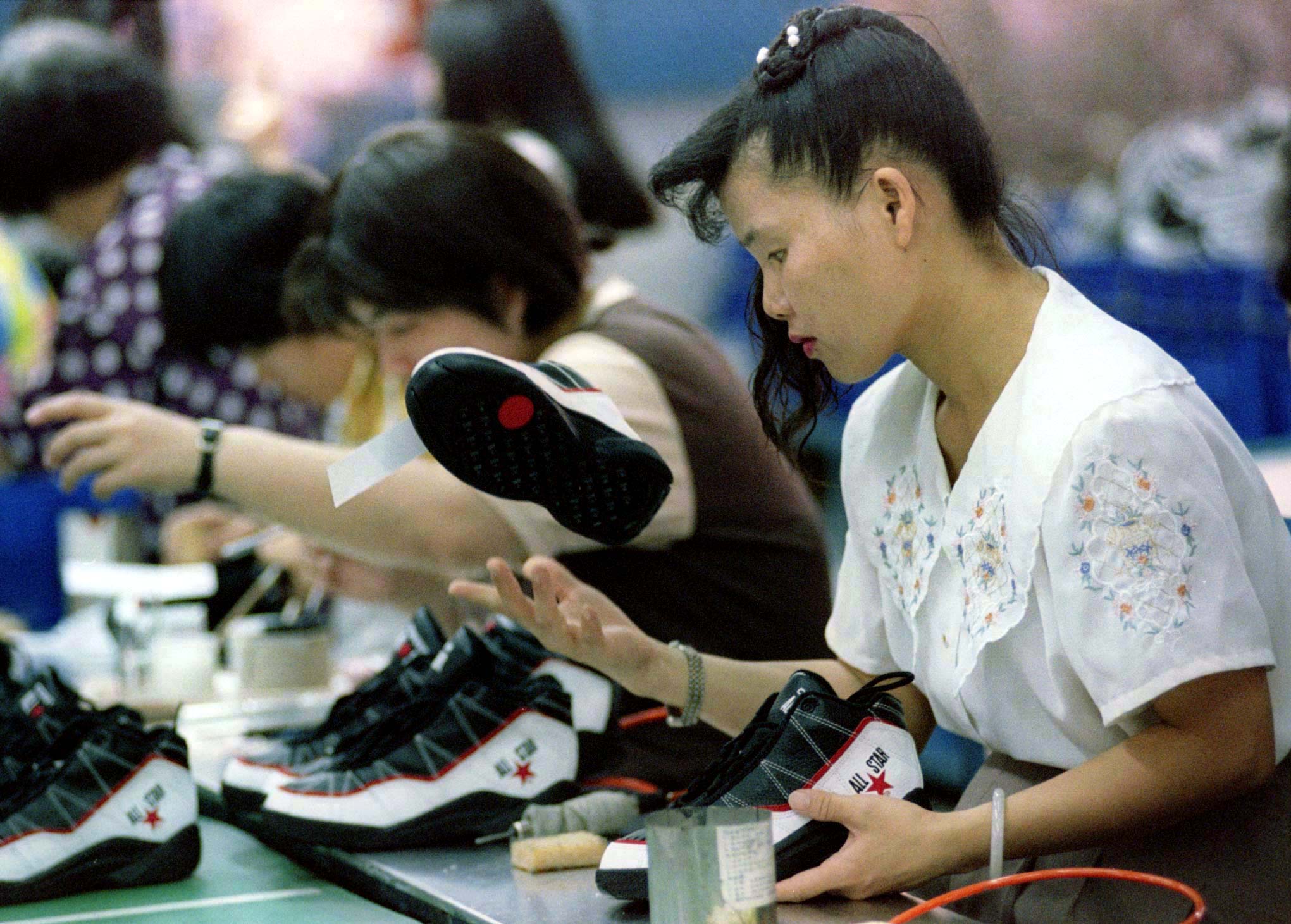 A production line worker inspects a sportshoe at the Pou Chen International Group's factory in centr..