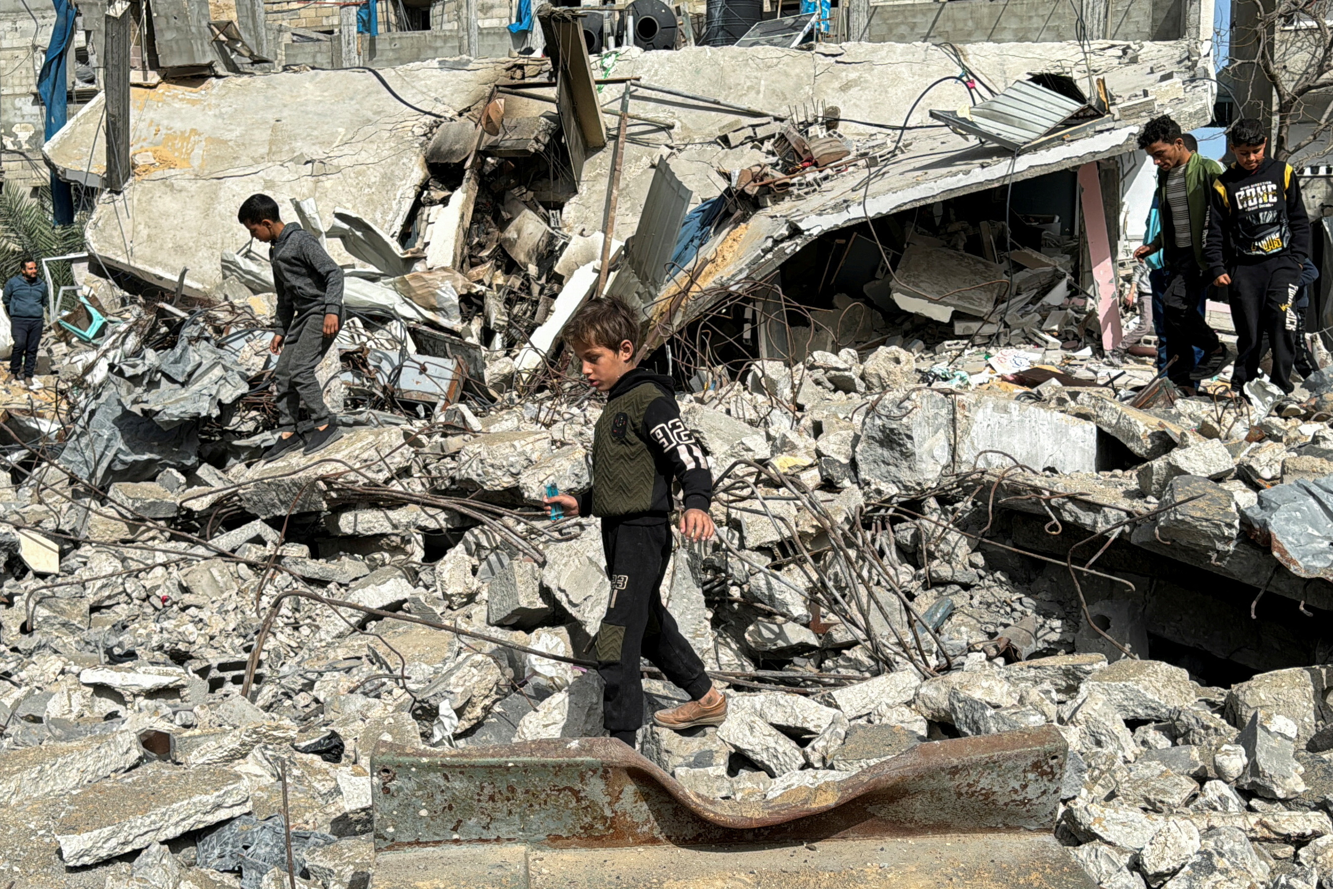 Palestinians inspect the site of an Israeli strike, in Rafah, in the southern Gaza Strip