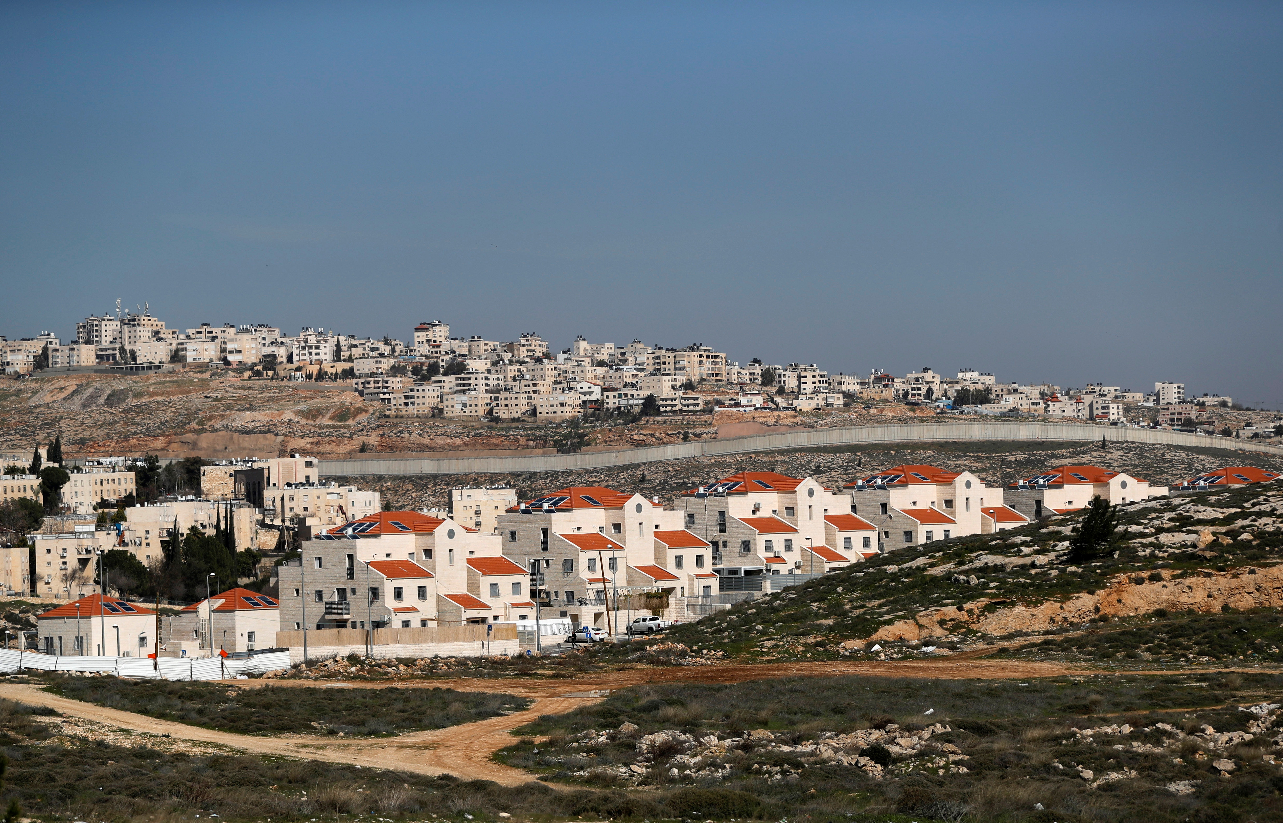 A view shows the Israeli settlement of Pisgat Zeev in the foreground as the Palestinian town of Al-Ram is seen in the background in the Israeli-occupied West Bank