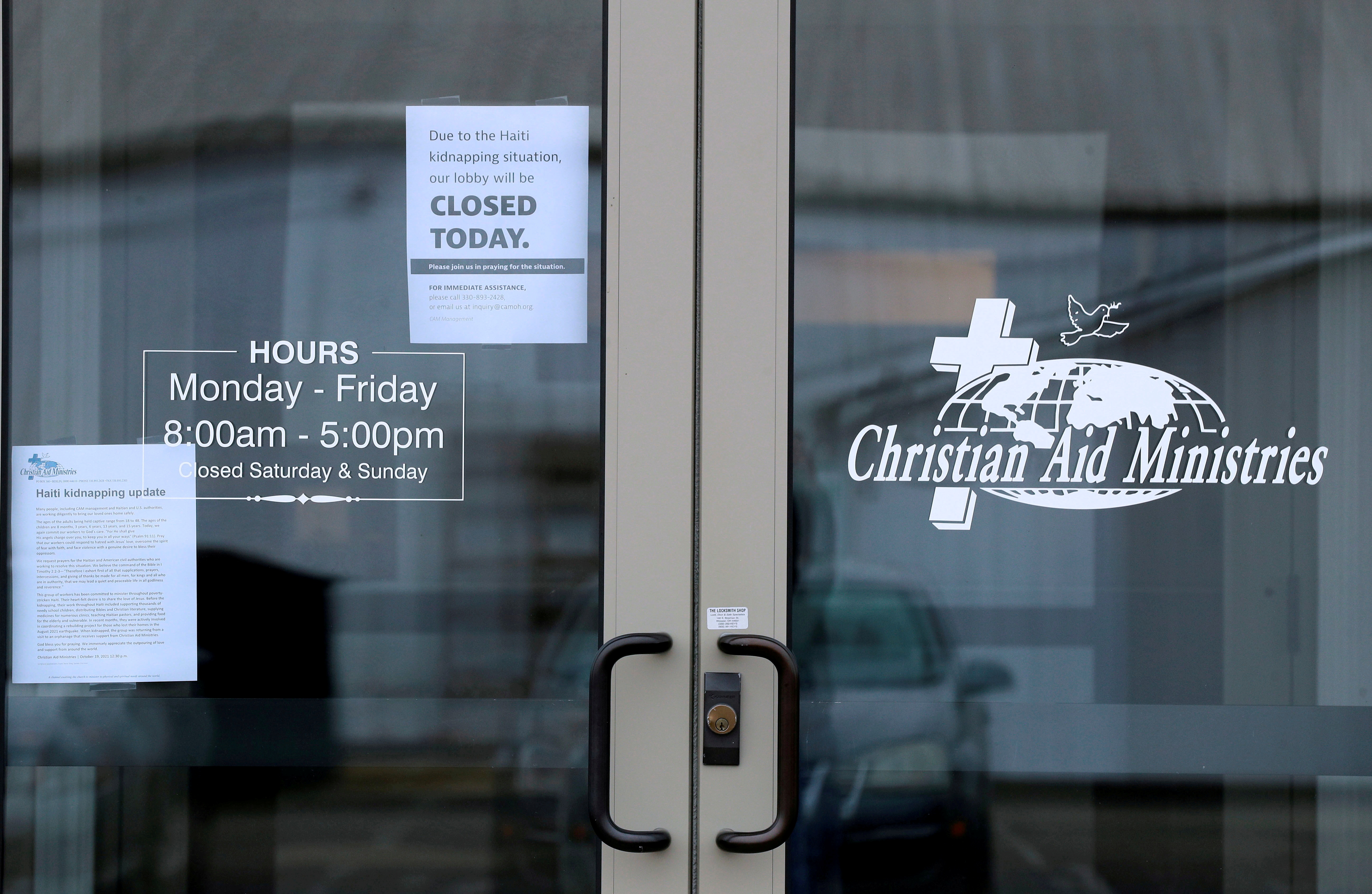 Signs on the door of the Christian Aid Ministries give updates on the Haiti kidnapping and show the the offices are closed in Millersburg, Ohio, U.S. October 21, 2021.  REUTERS/Aaron Josefczyk/File Photo