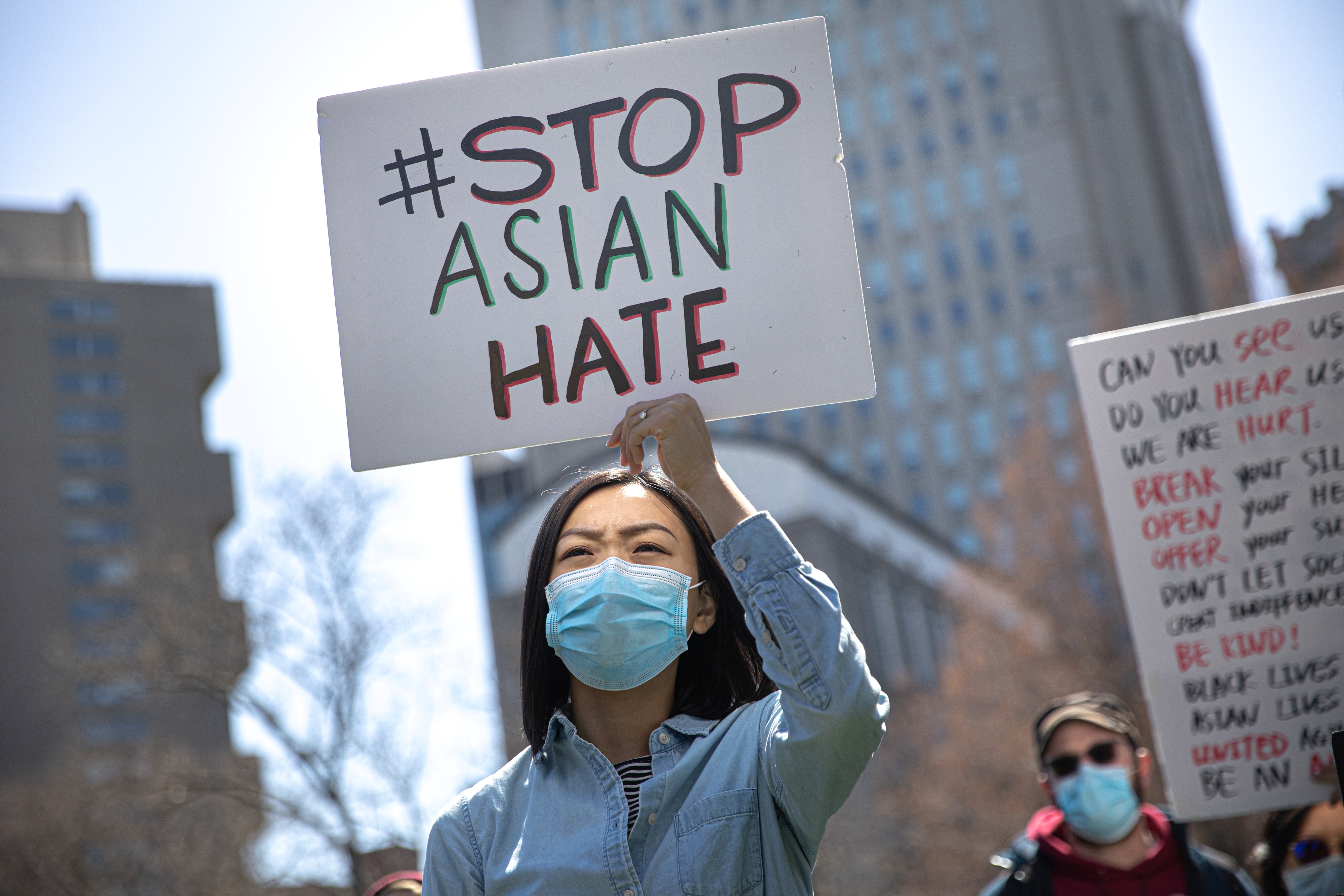 A woman holds a placard as she participates in a Stop Asian Hate rally at Columbus Park in New York City, U.S., April 3, 2021. REUTERS/Jeenah Moon