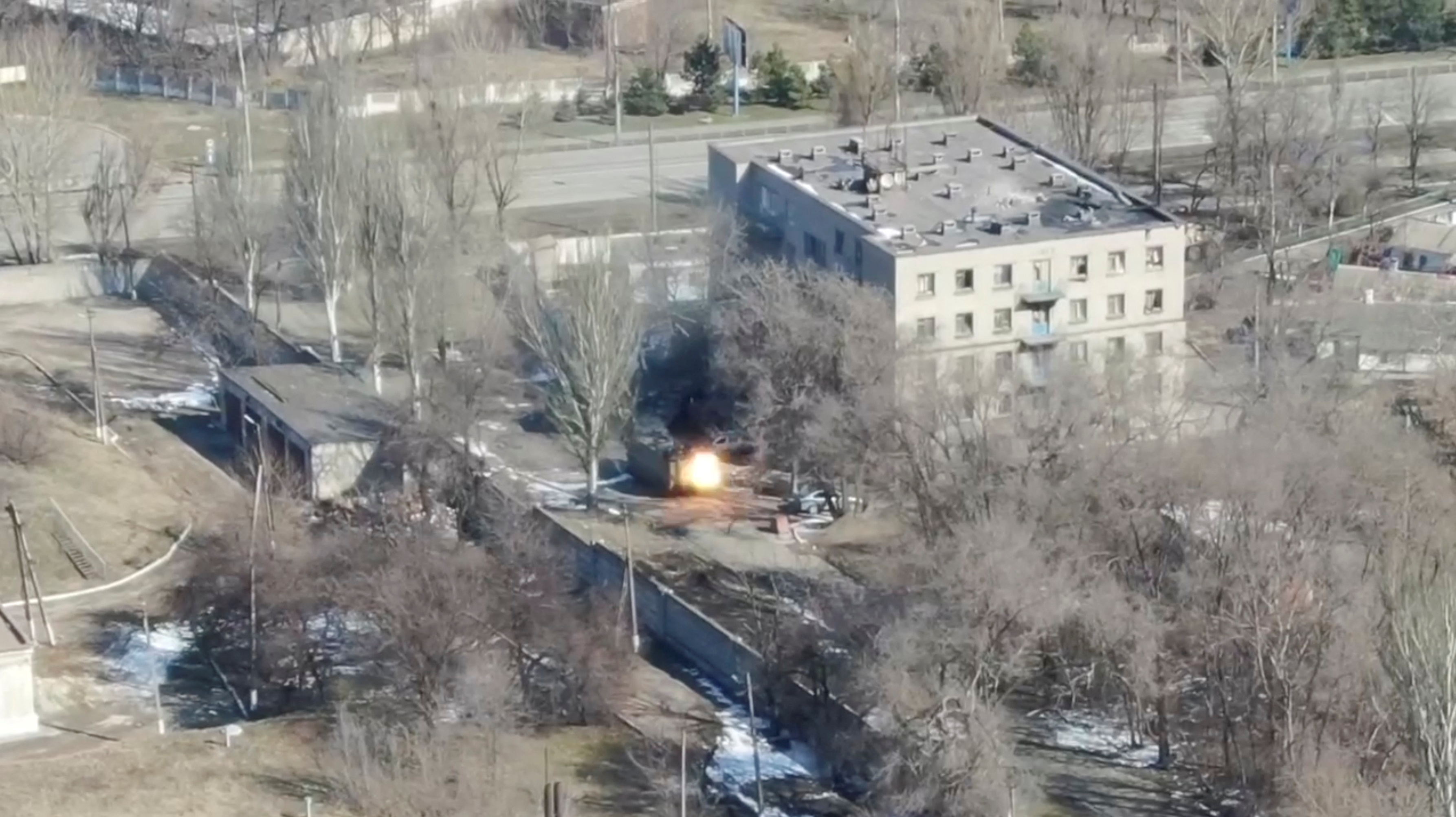 An aeriel view shows an armoured vehicle shoot rounds next to a building, as Russia's invasion of Ukraine continues, in Maripuol