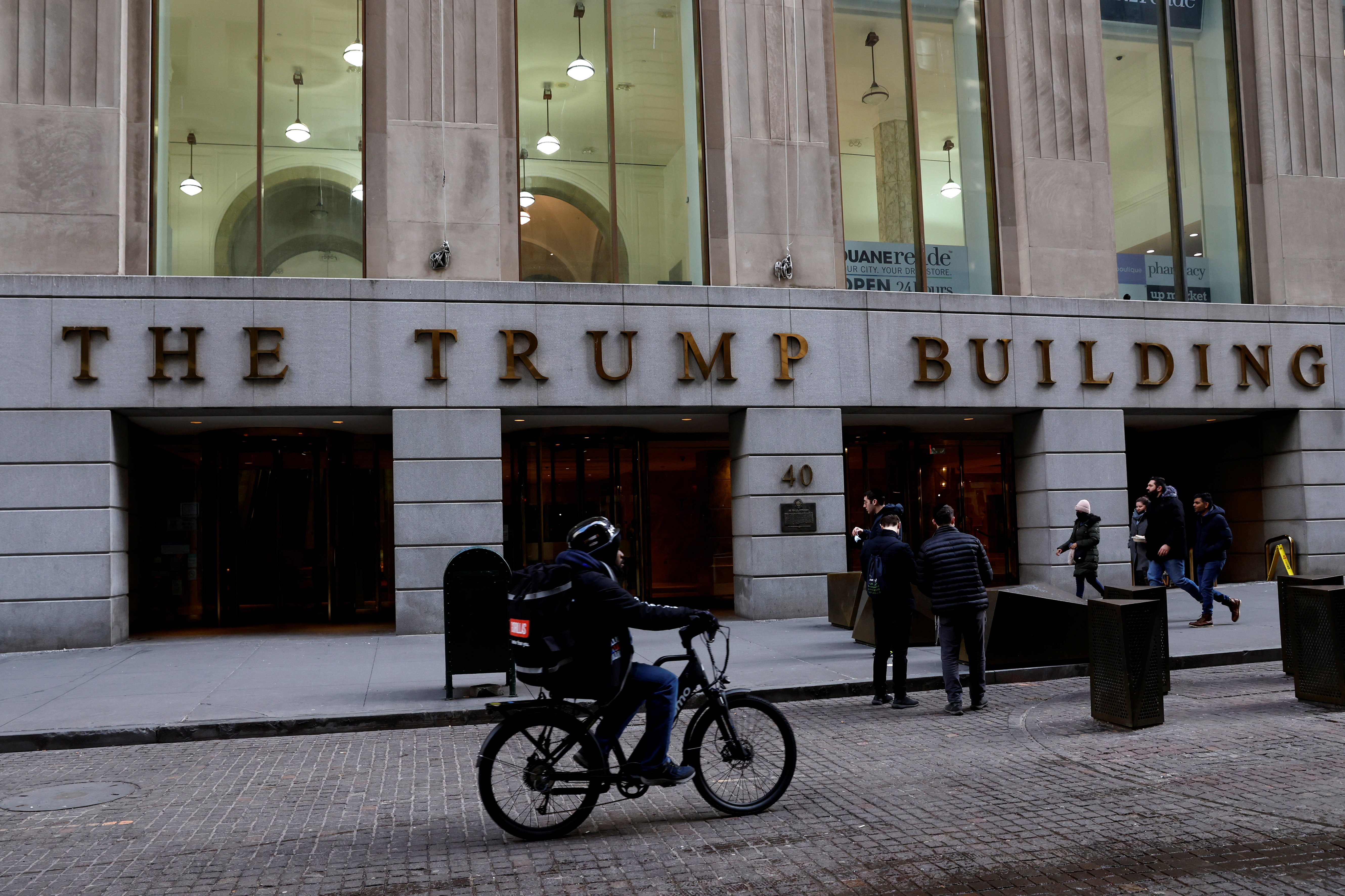 People walk outside 40 Wall Street, also known as the Trump Building, in the Manhattan borough of New York