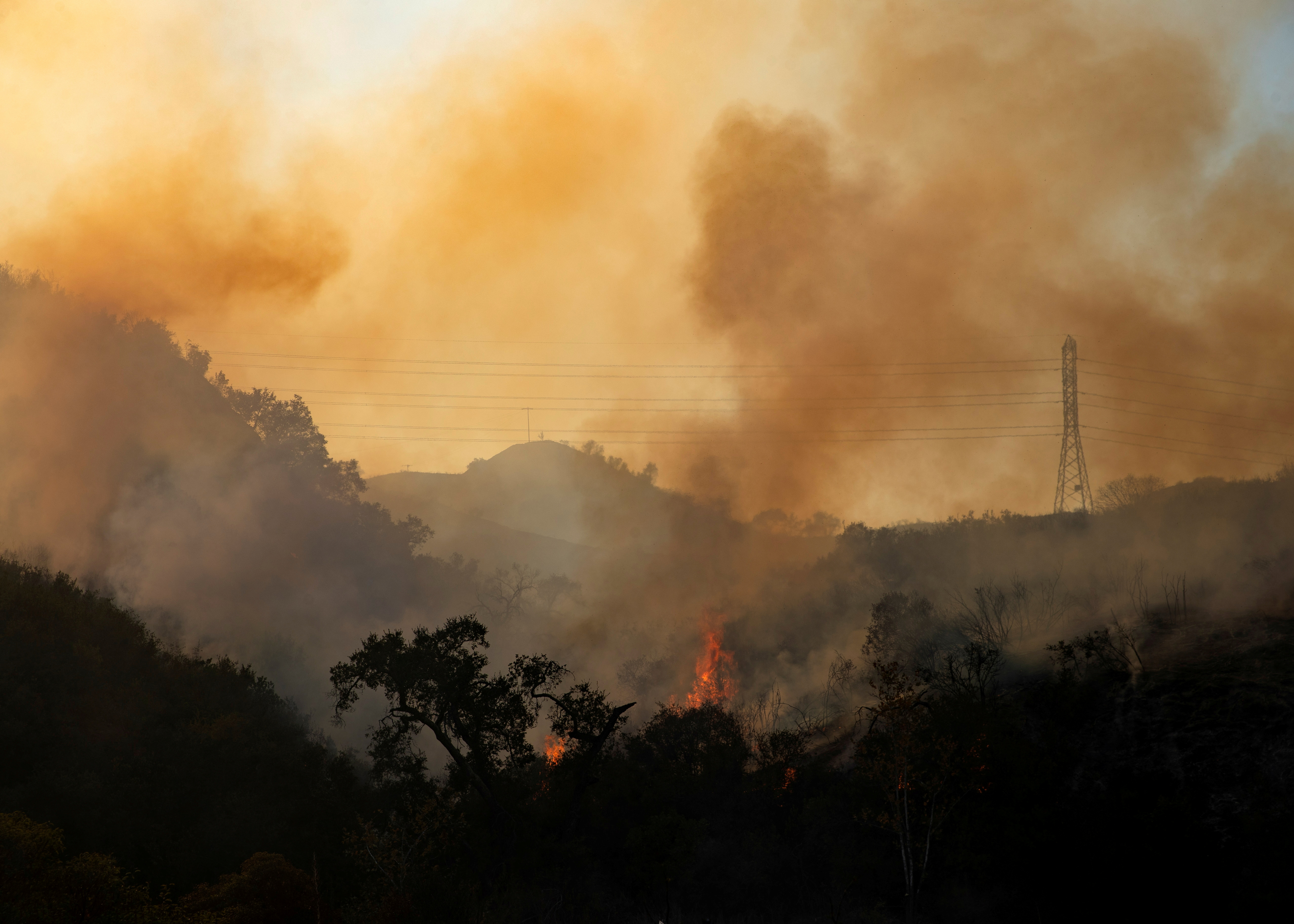 The Bond Fire wildfire burns next to electrical power lines near Modjeska Canyon, California, U.S., December 3, 2020.  REUTERS/Mike Blake