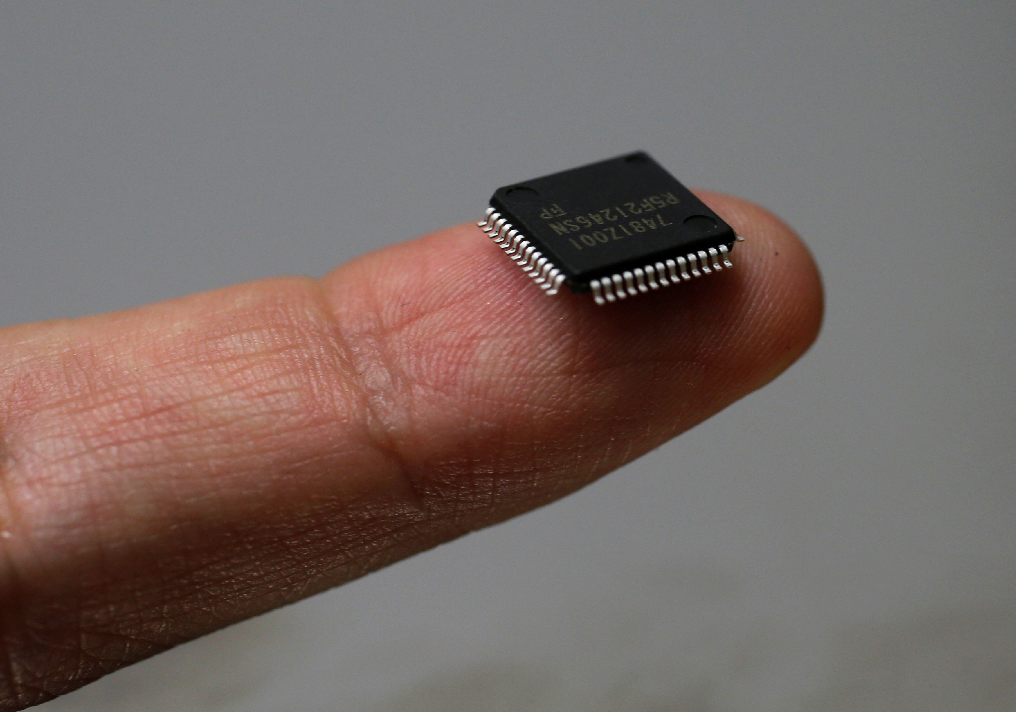 A Renesas Electronics Corp microcontroller chip sits on a finger in this illustrative photograph