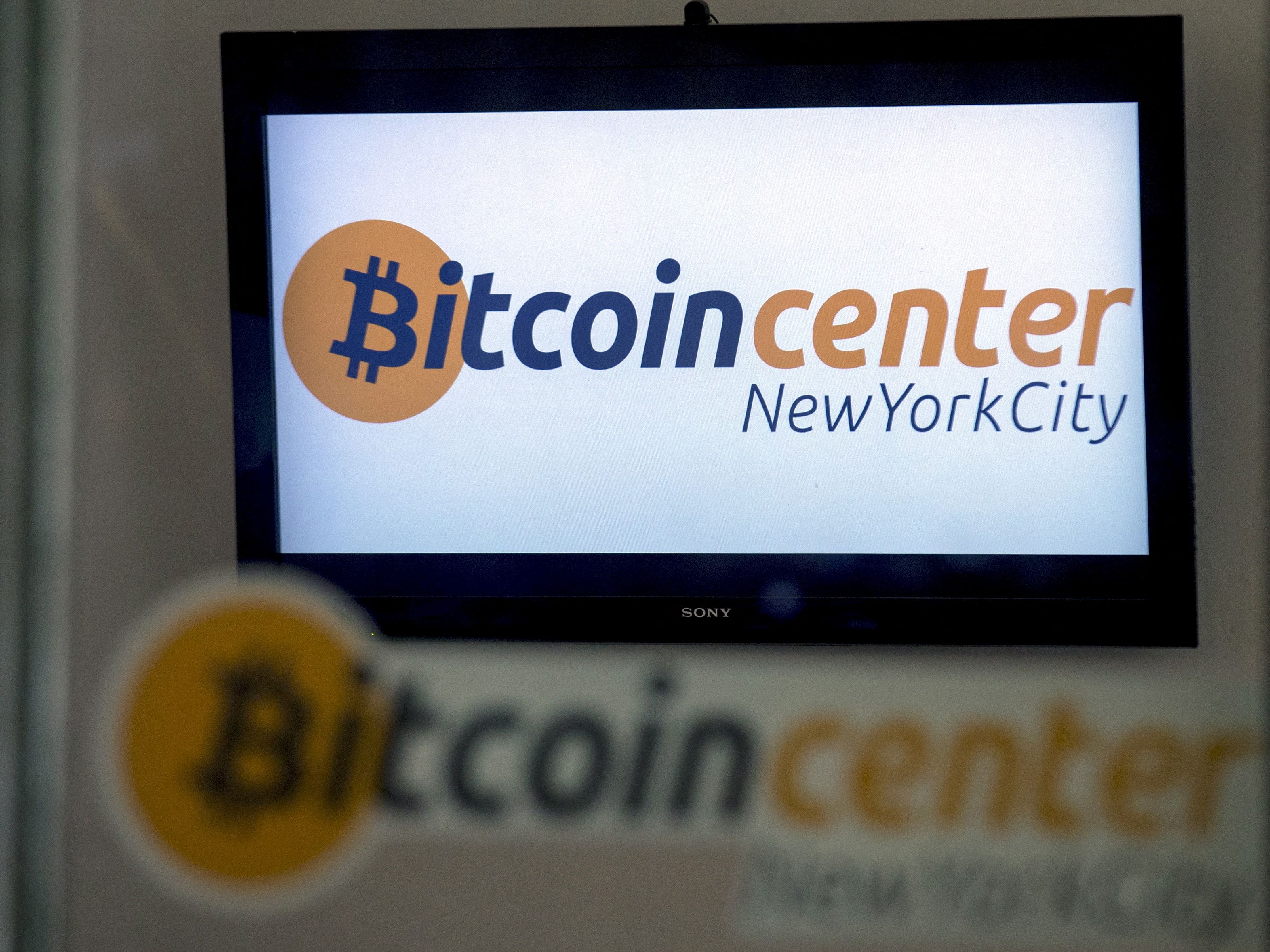A Bitcoin logo is displayed on a screen inside the Bitcoin Center New York City in New York's financial district