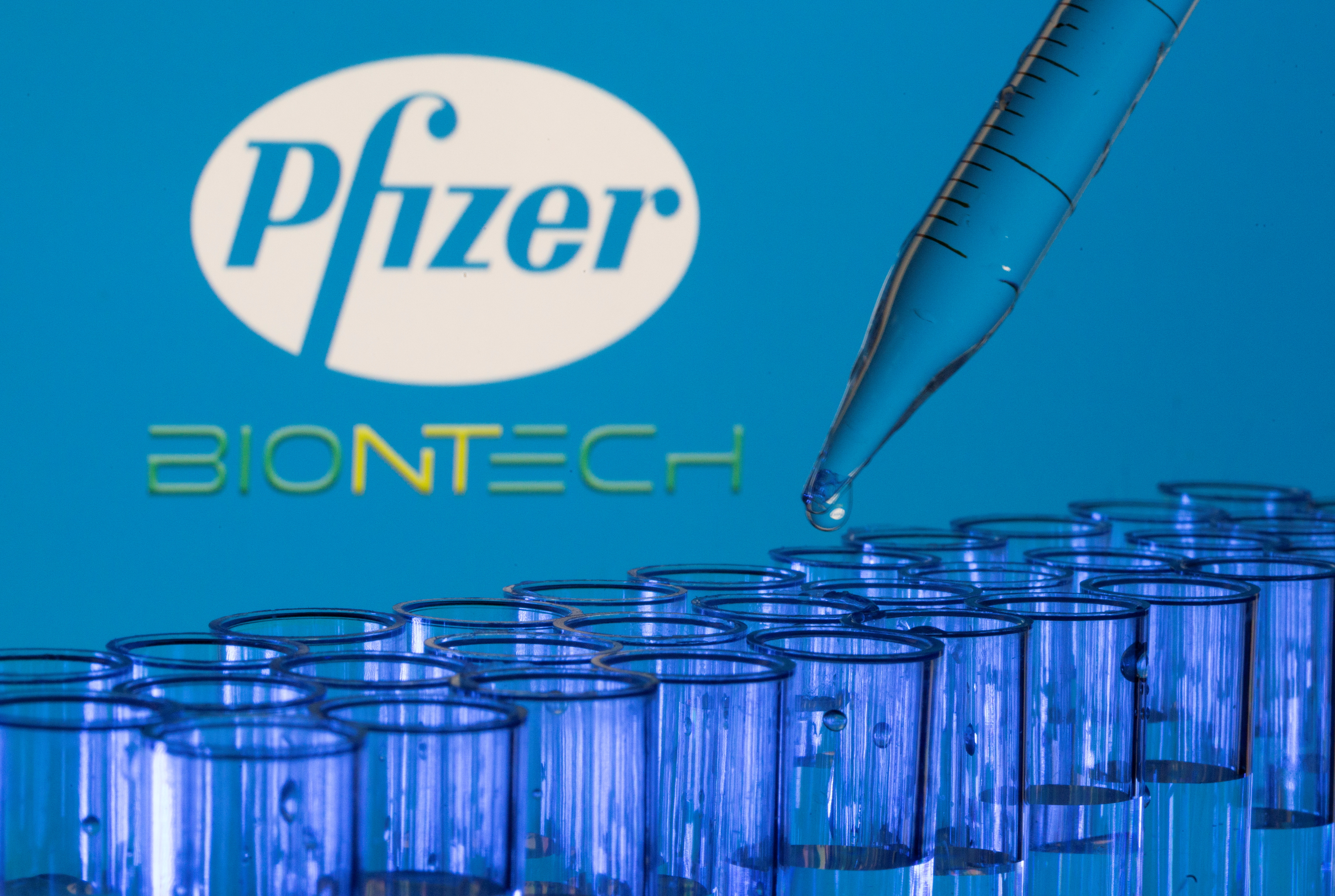 Test tubes are seen in front of displayed Pfizer and Biontech logos in this illustration