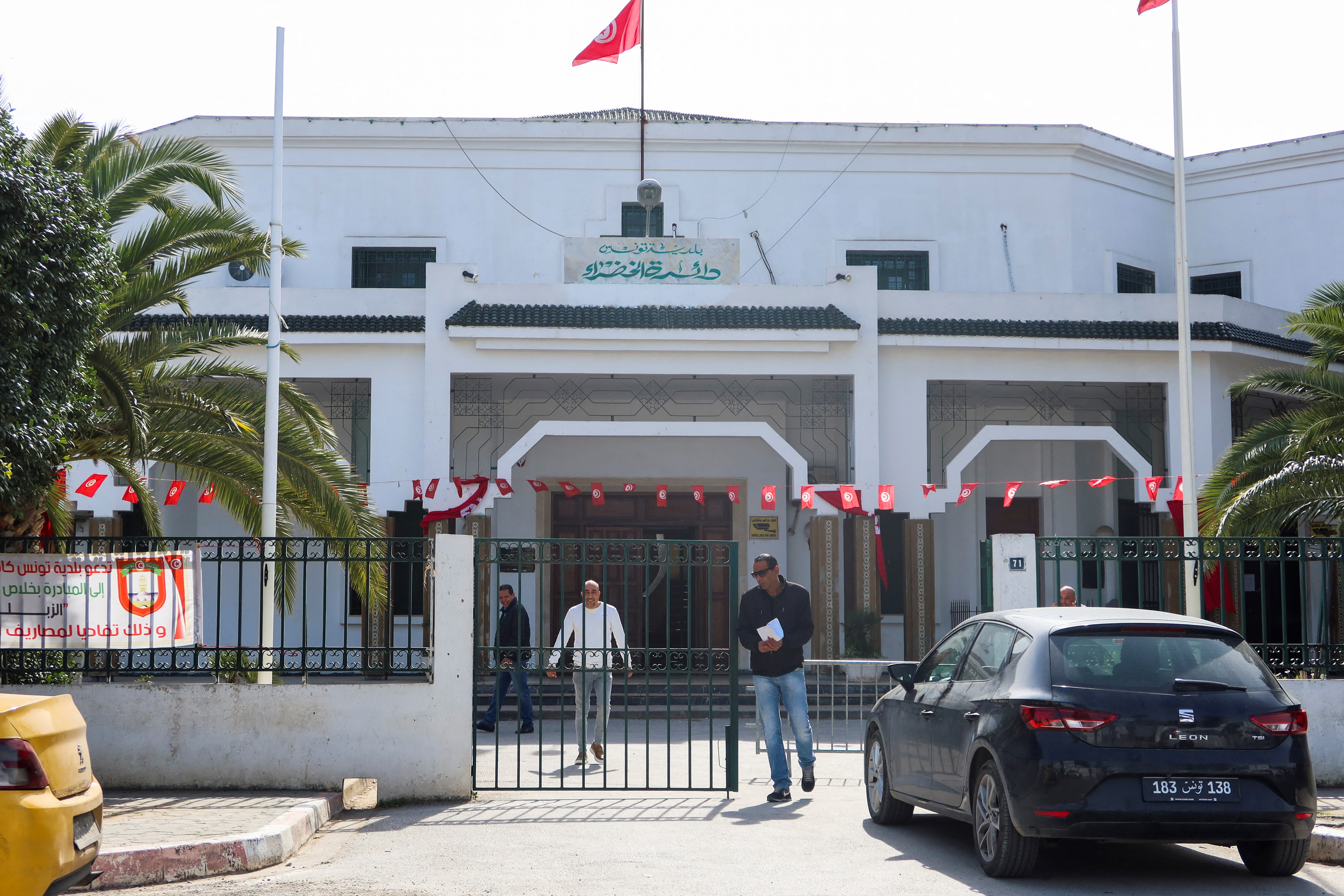 Men walk outside the building of Tunis municipality