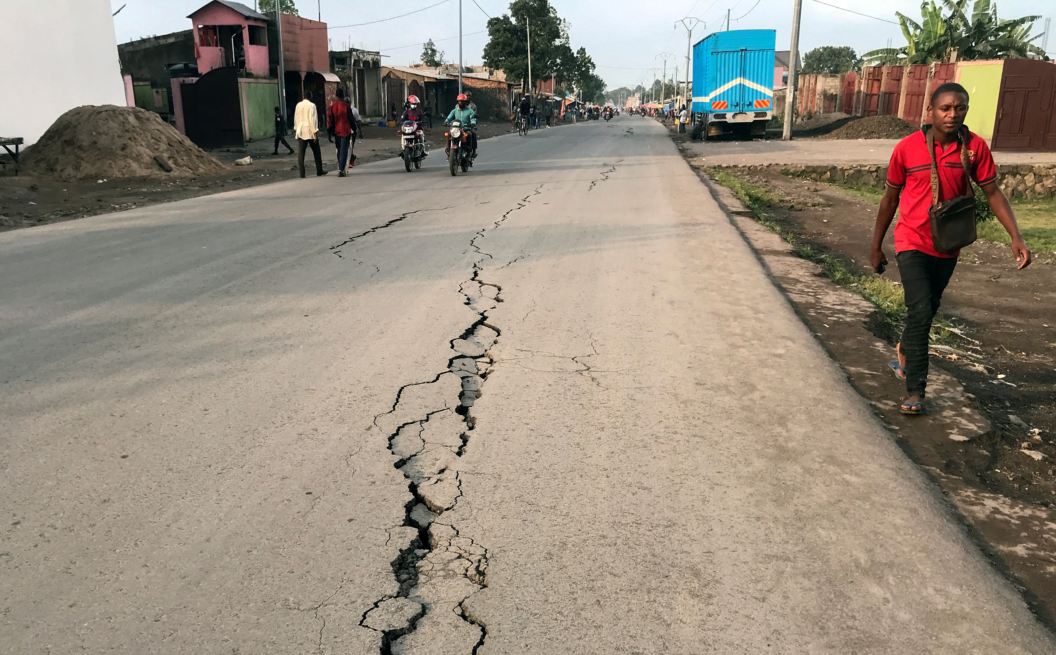A pedestrian walks near a crack on the road caused by earth tremors as aftershocks following the eruption of Mount Nyiragongo volcano near Goma, in the Democratic Republic of Congo May 26, 2021. REUTERS/Djaffar Al Katanty