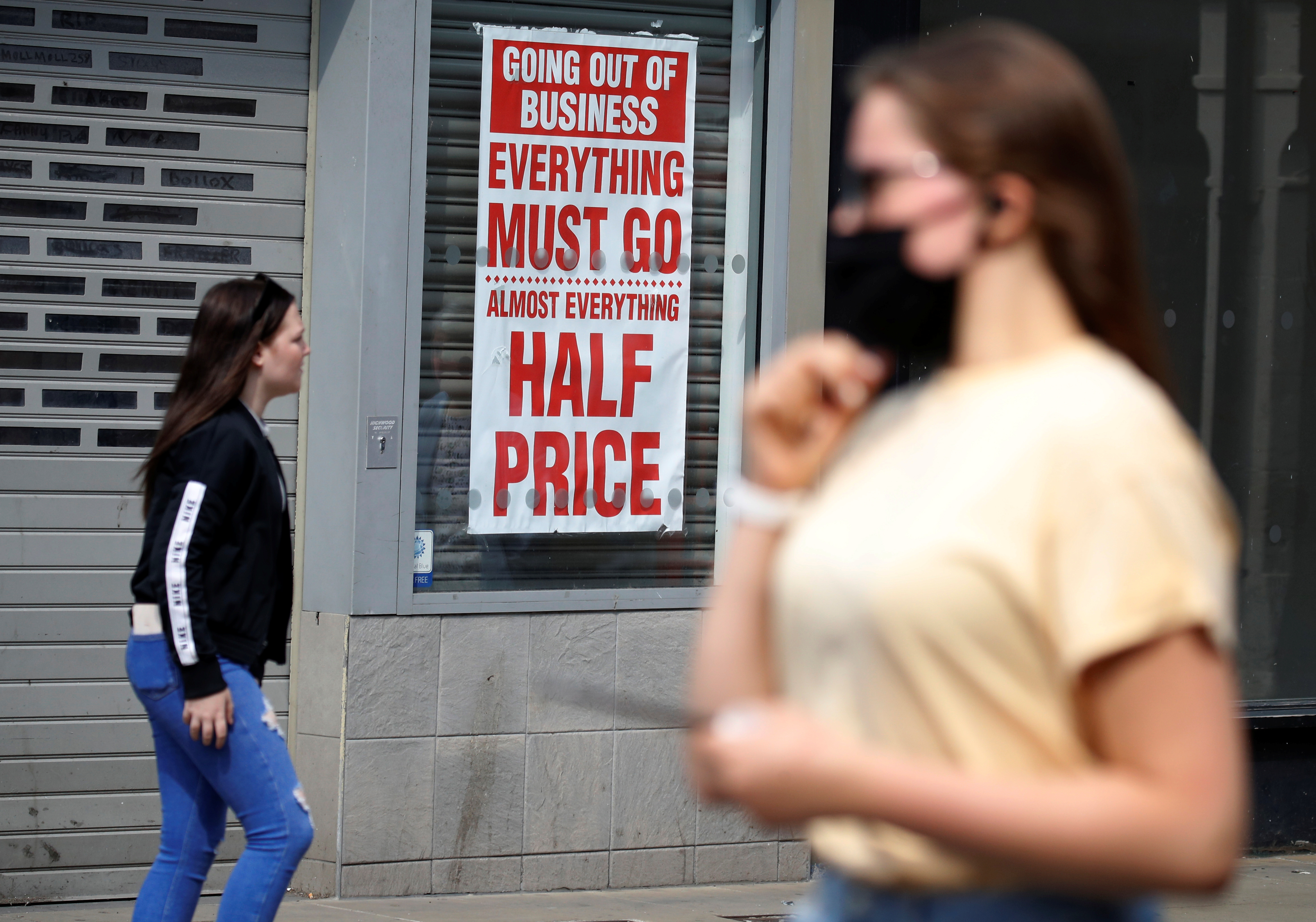 People walk past a closed shop following the outbreak of the coronavirus disease (COVID-19) in Chester, Britain