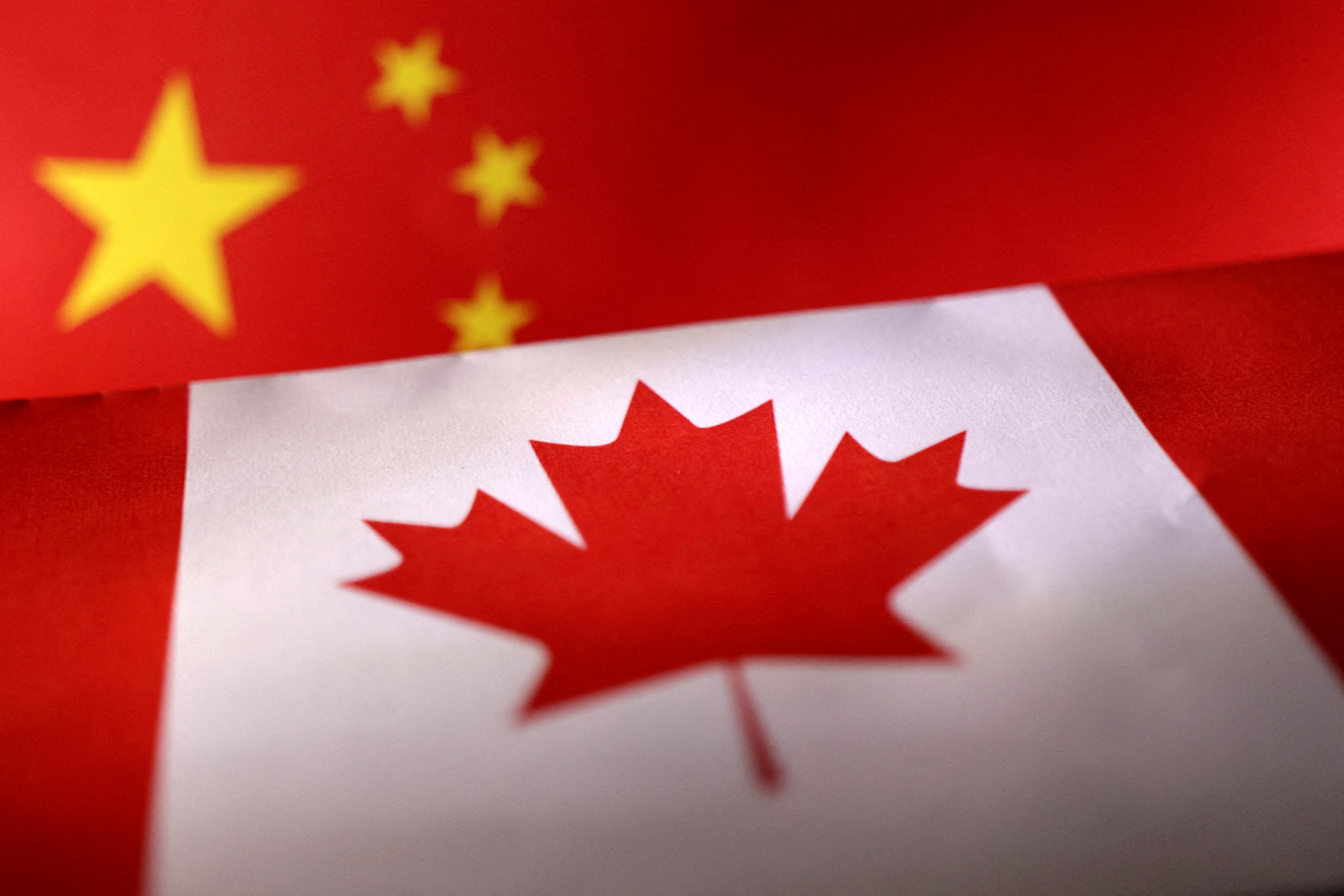 Illustration shows printed Chinese and Canada flags