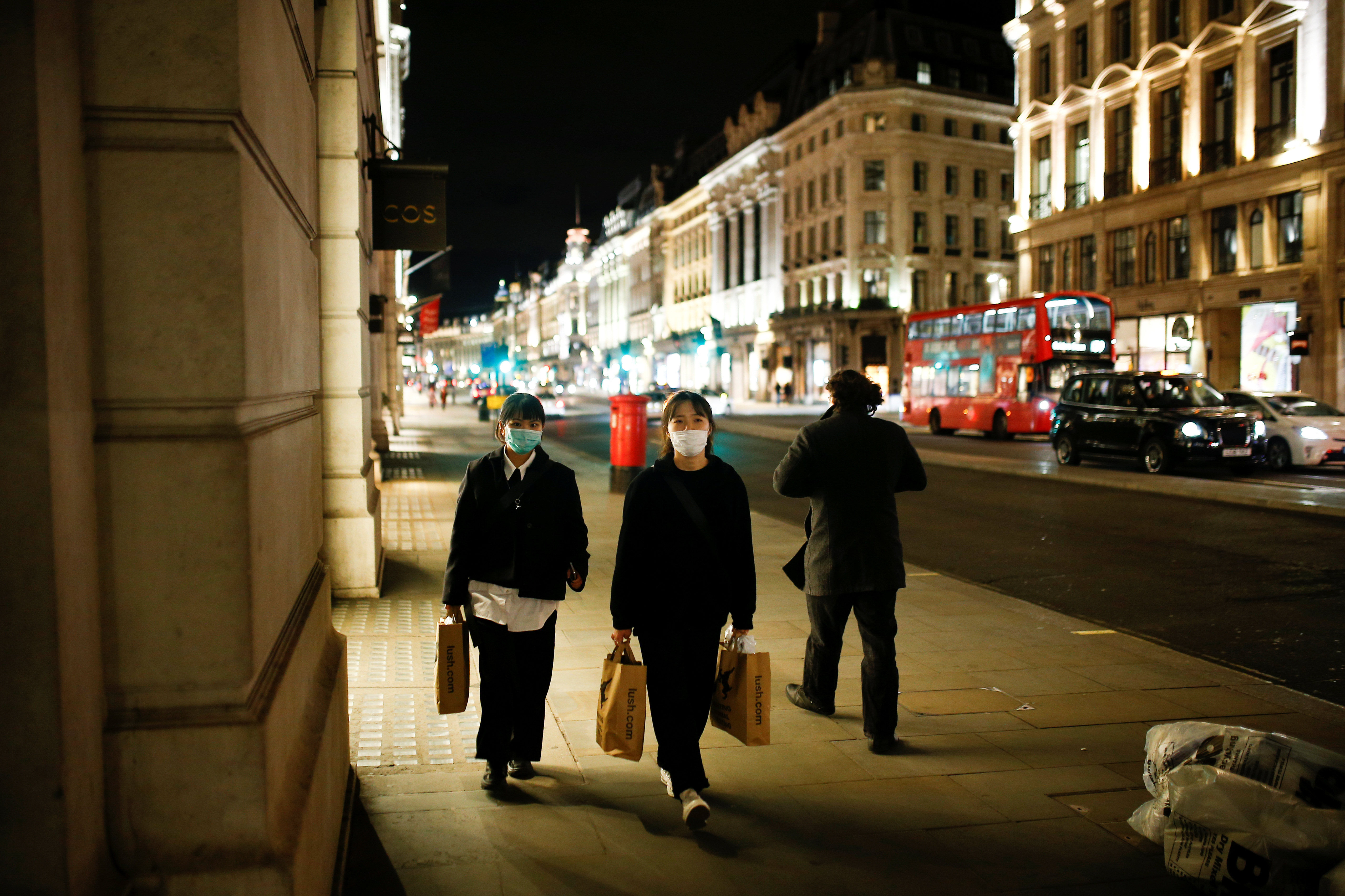 People wearing face masks walk down Regent Street, as the number of coronavirus (COVID-19) cases grow around the world, in London