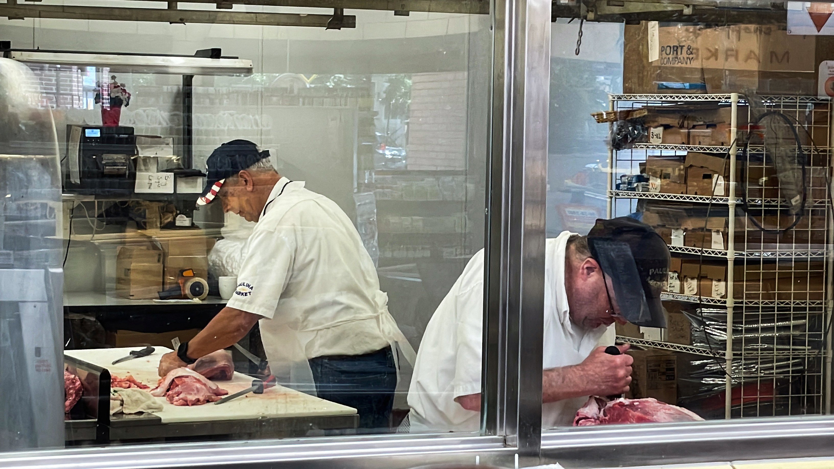 Owner, William Begale, and one of his employees cut meat in the butcher's cutting room at Paulina Meat Market in Chicago