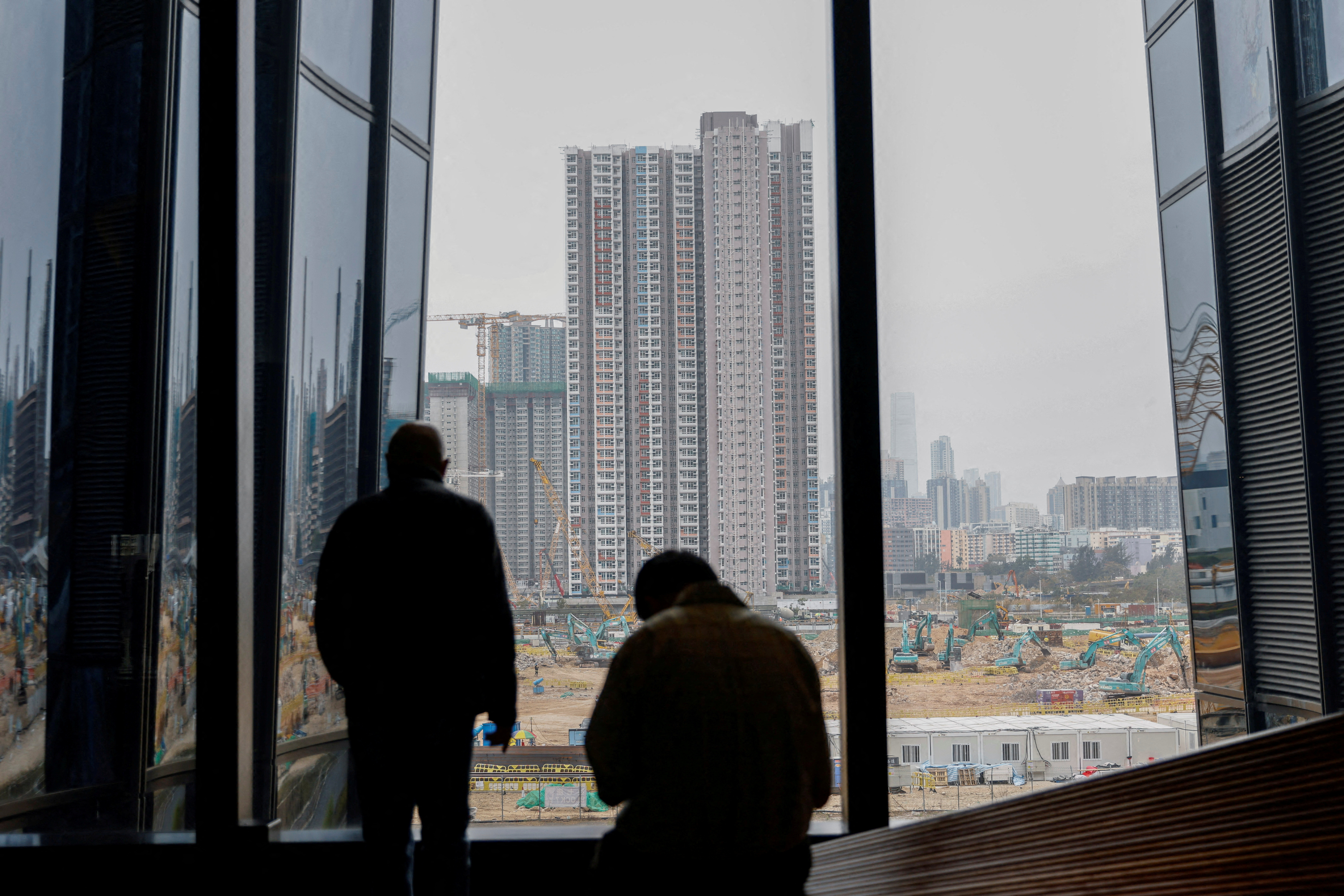 A man looks at the construction site of residential units, in Hong Kong
