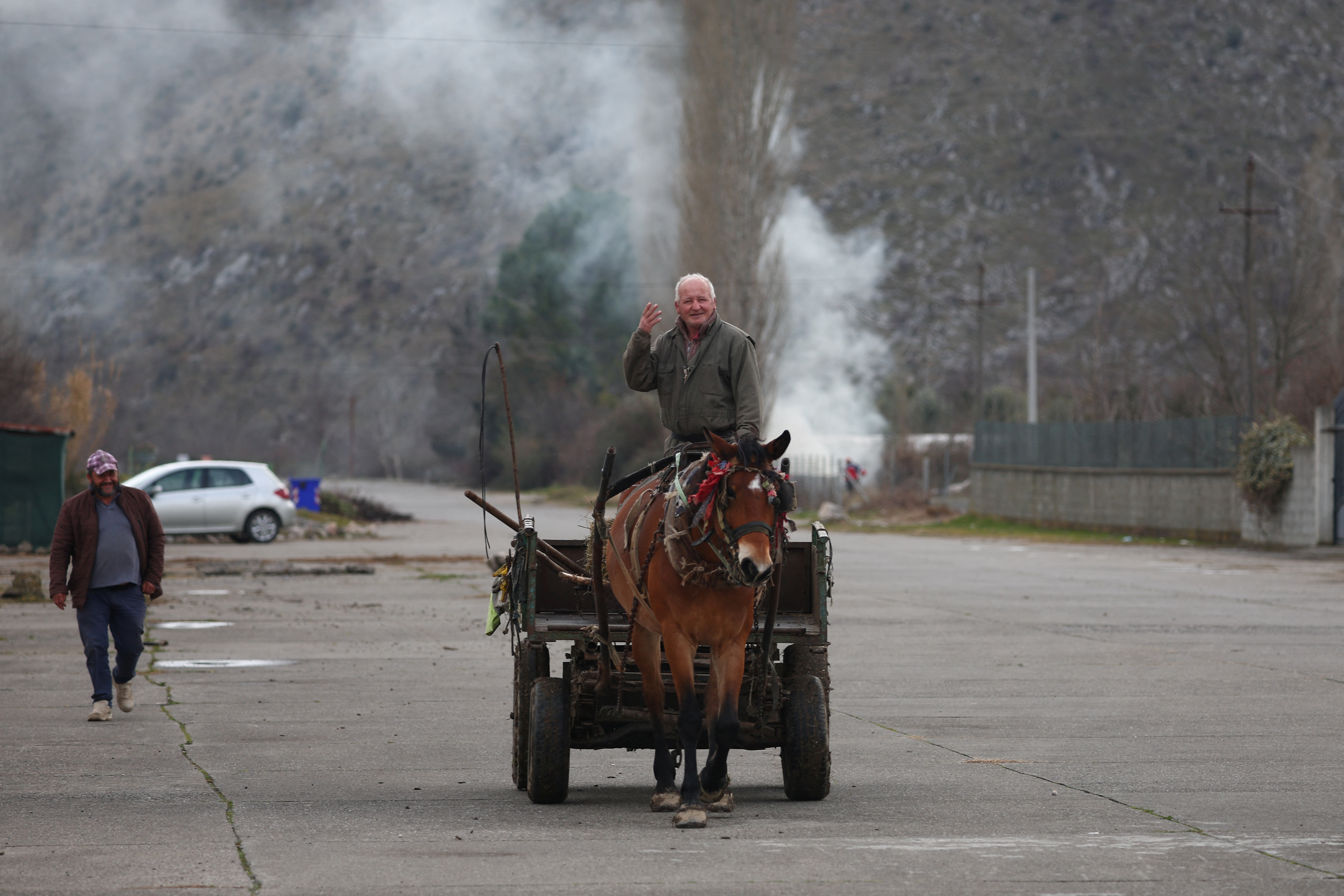 A local man riding a horse gestures on a former runaway of a military airport, in Gjader