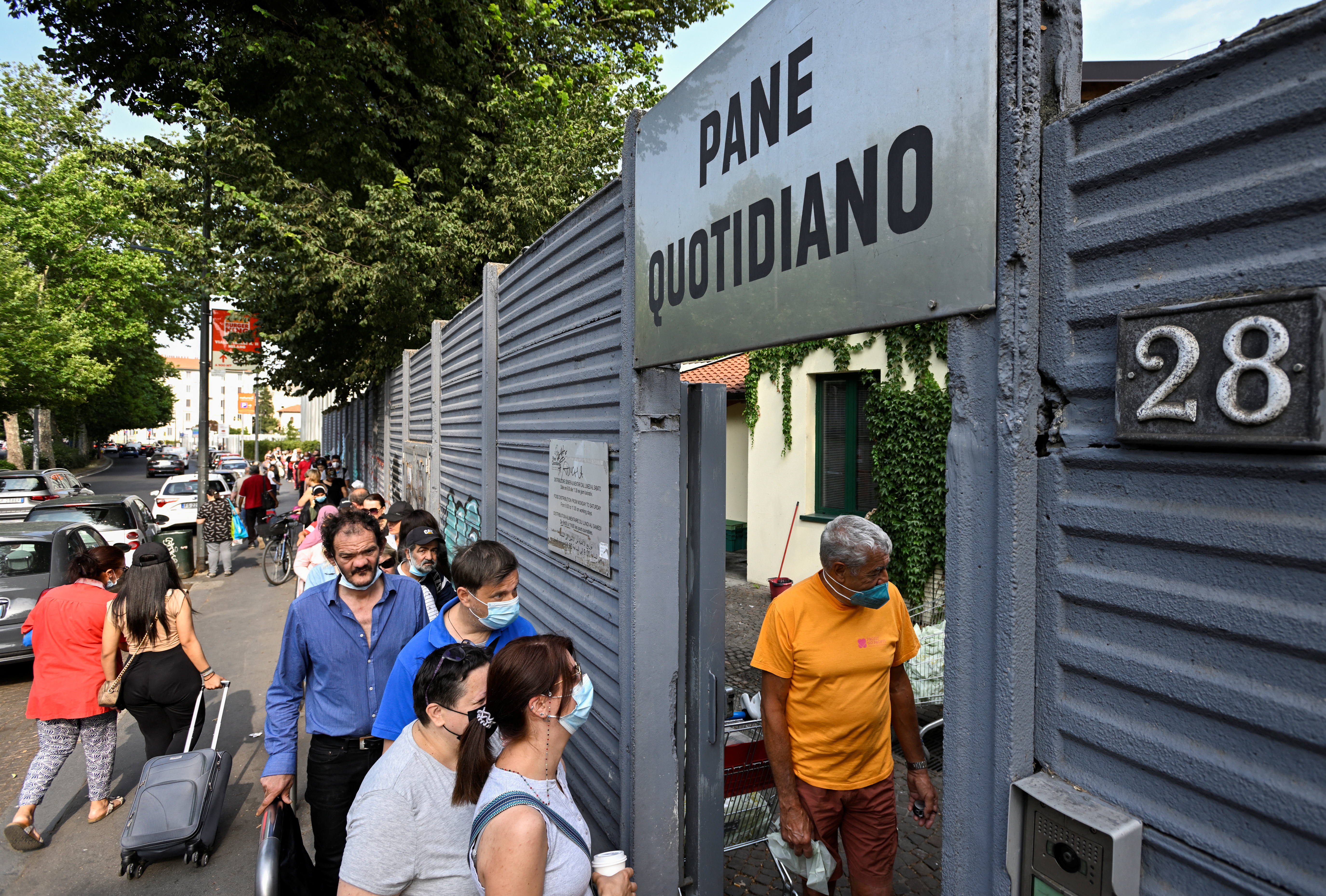 People queue for free food as Italy faces the problem of zero wage growth for the last thirty years, in Milan