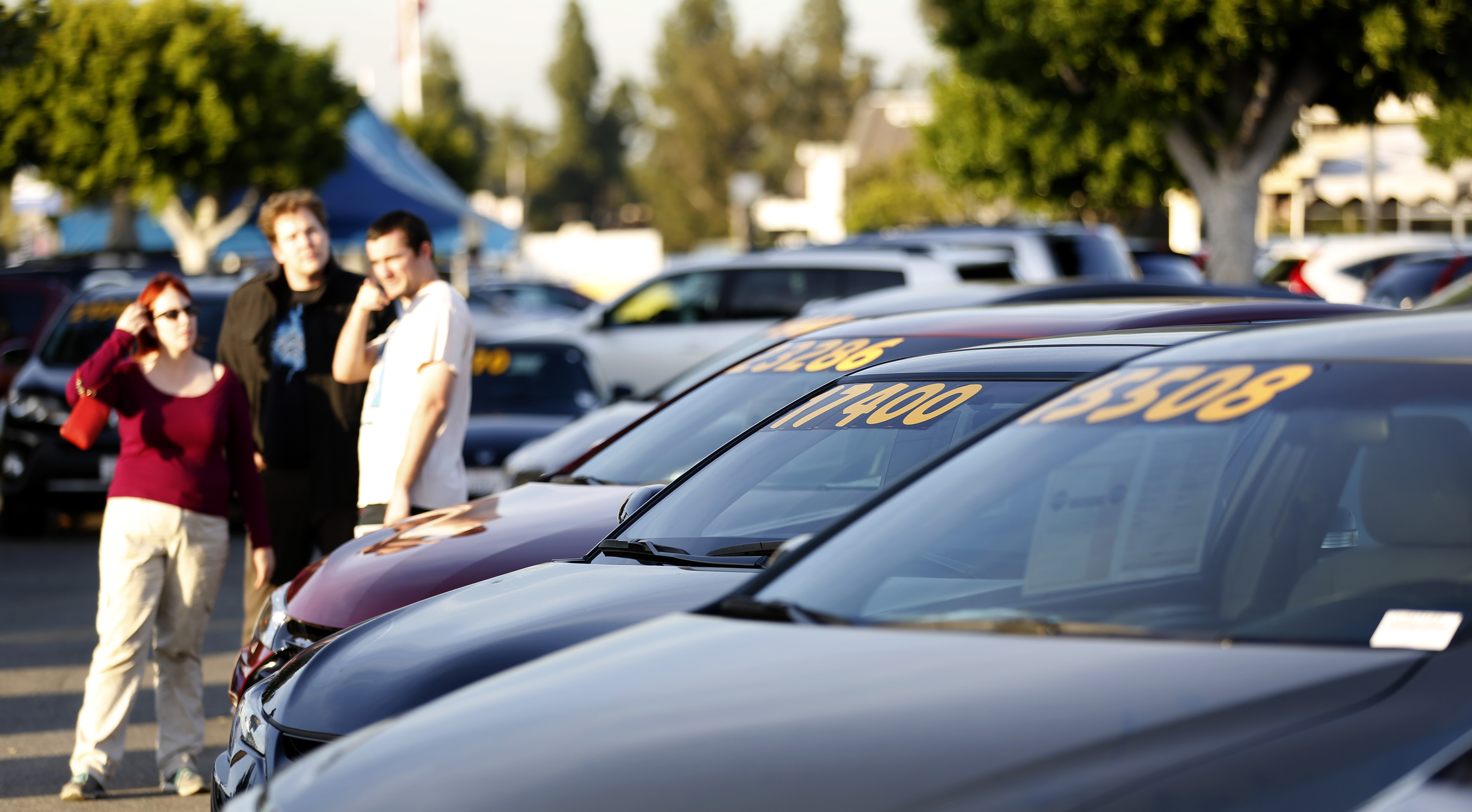 People look at vehicles for sale on the lot at AutoNation dealership in Cerritos