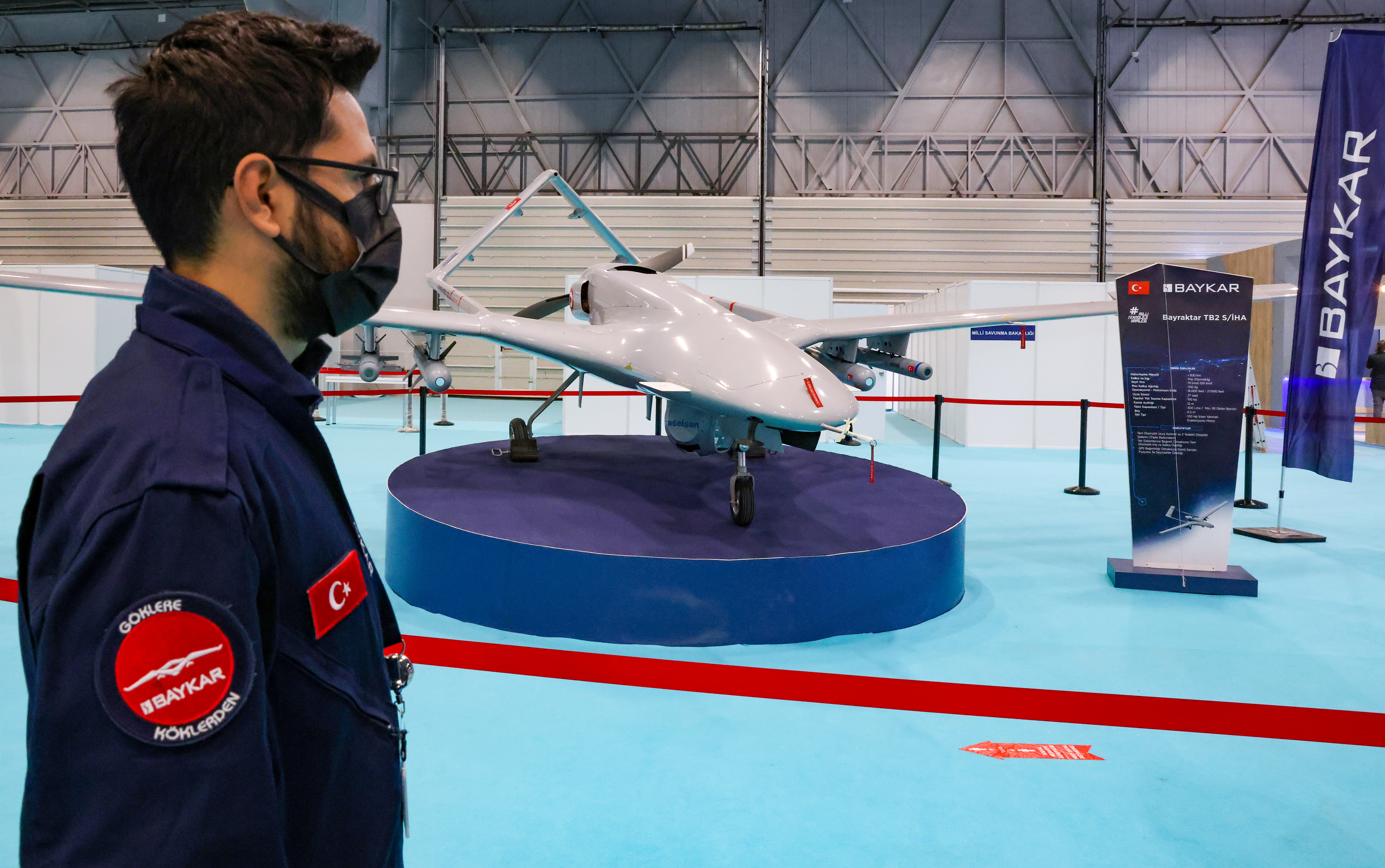 An engineer from Turkish drone-maker Baykar stands next to a TB2 drone during the first day of SAHA EXPO Defence & Aerospace Exhibition in Istanbul