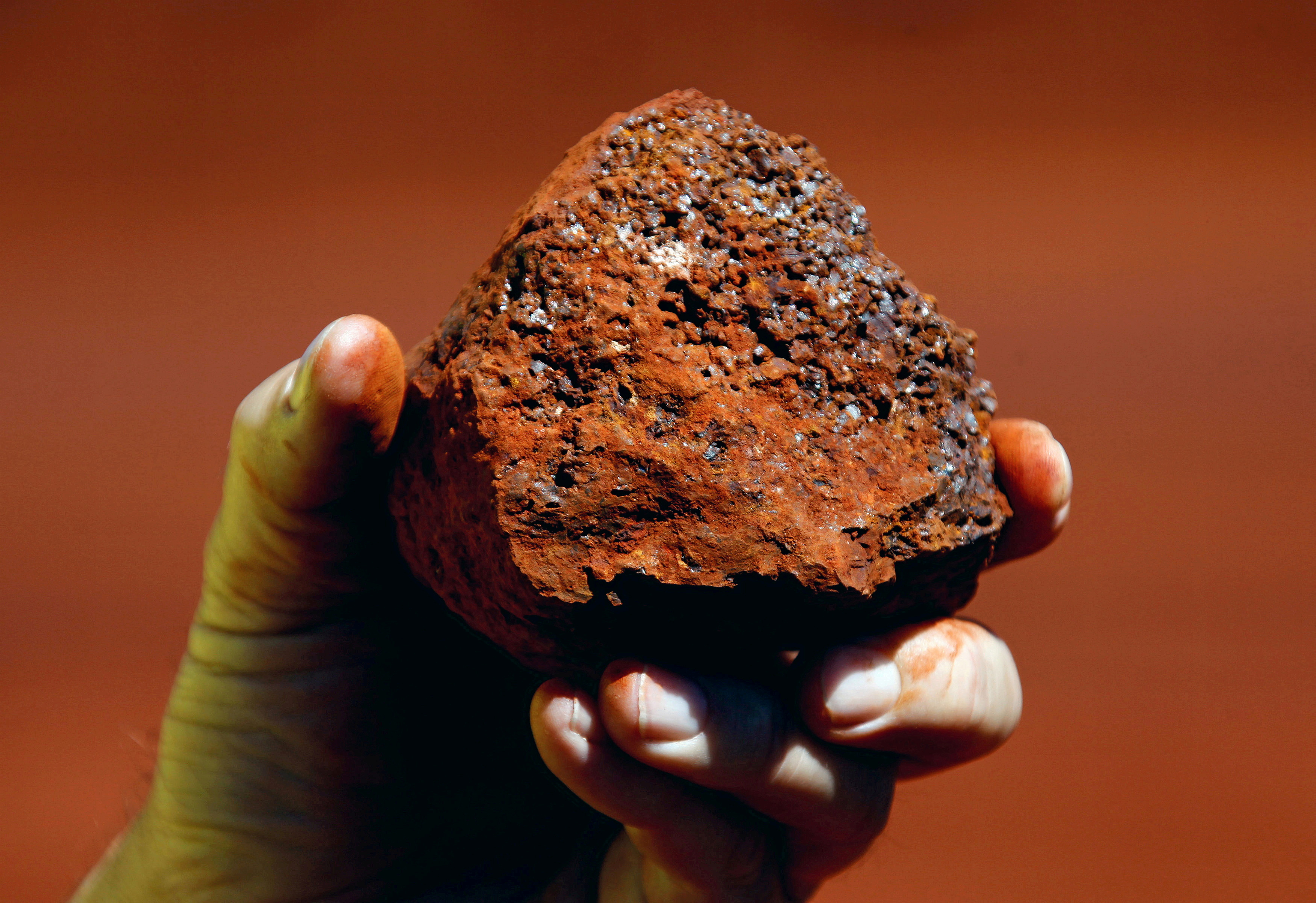 File photo of a miner holding a lump of iron ore at a mine located in the Pilbara region of Western Australia