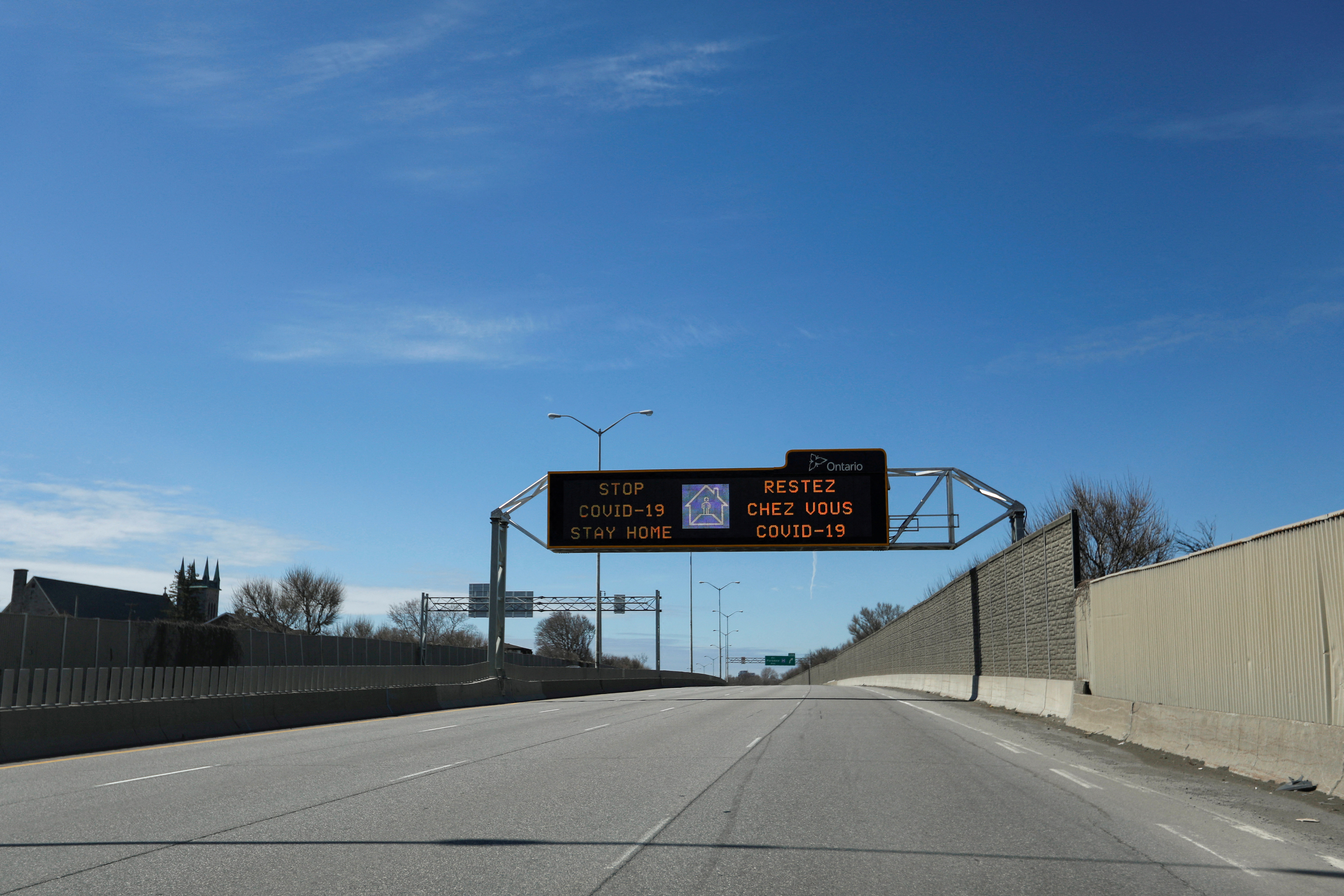A digital traffic sign is seen above an empty highway 417, in Ottawa, Ontario