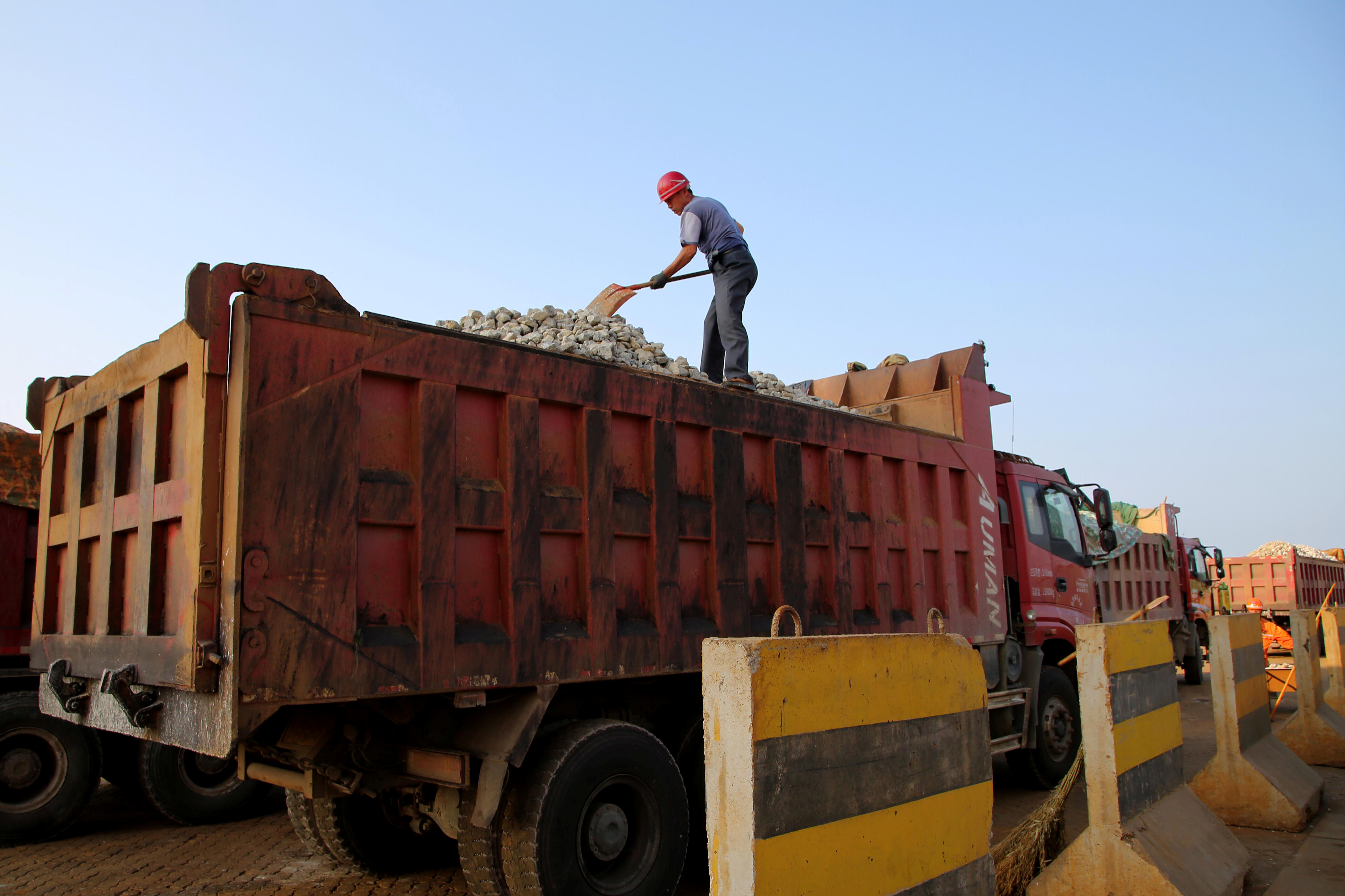 A man works on transporting iron ore on a truck at Ganyu port in Lianyungang