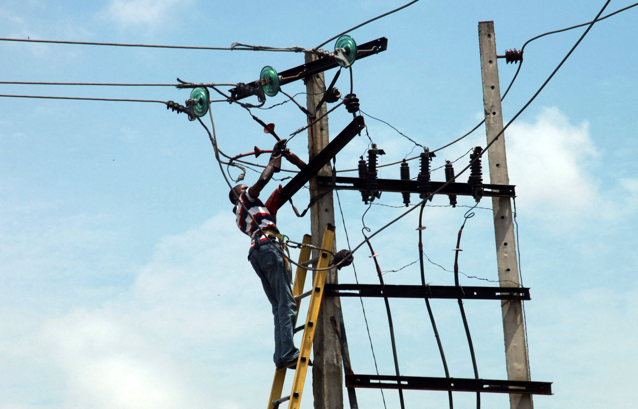 A power official works on an electric pole along a street in Nigeria's commercial capital Lagos