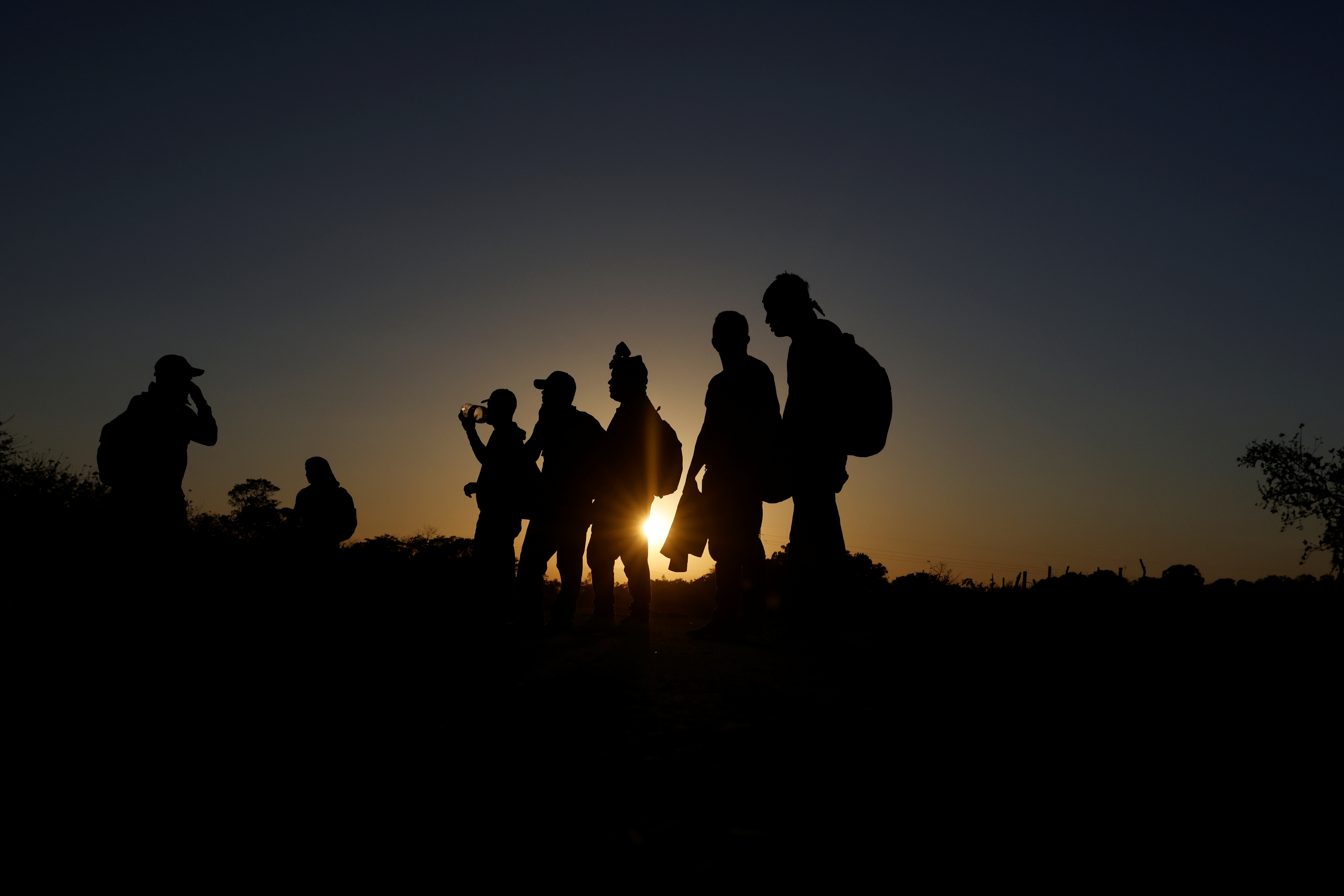 A group of migrants from Honduras take a short rest along a path on their way to the United States in Palenque