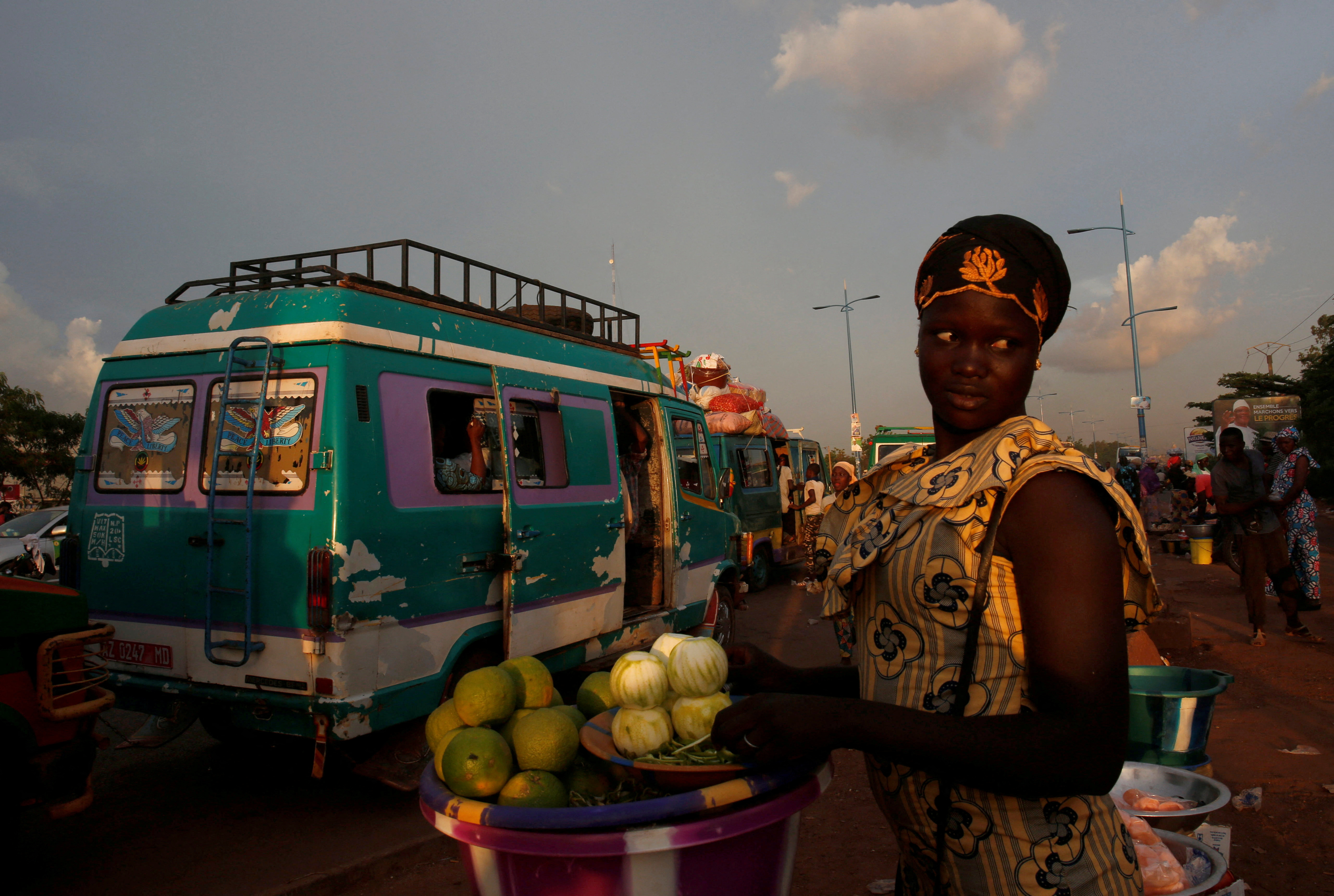 A street vendor sells oranges at a mini bus station in Bamako, Mali