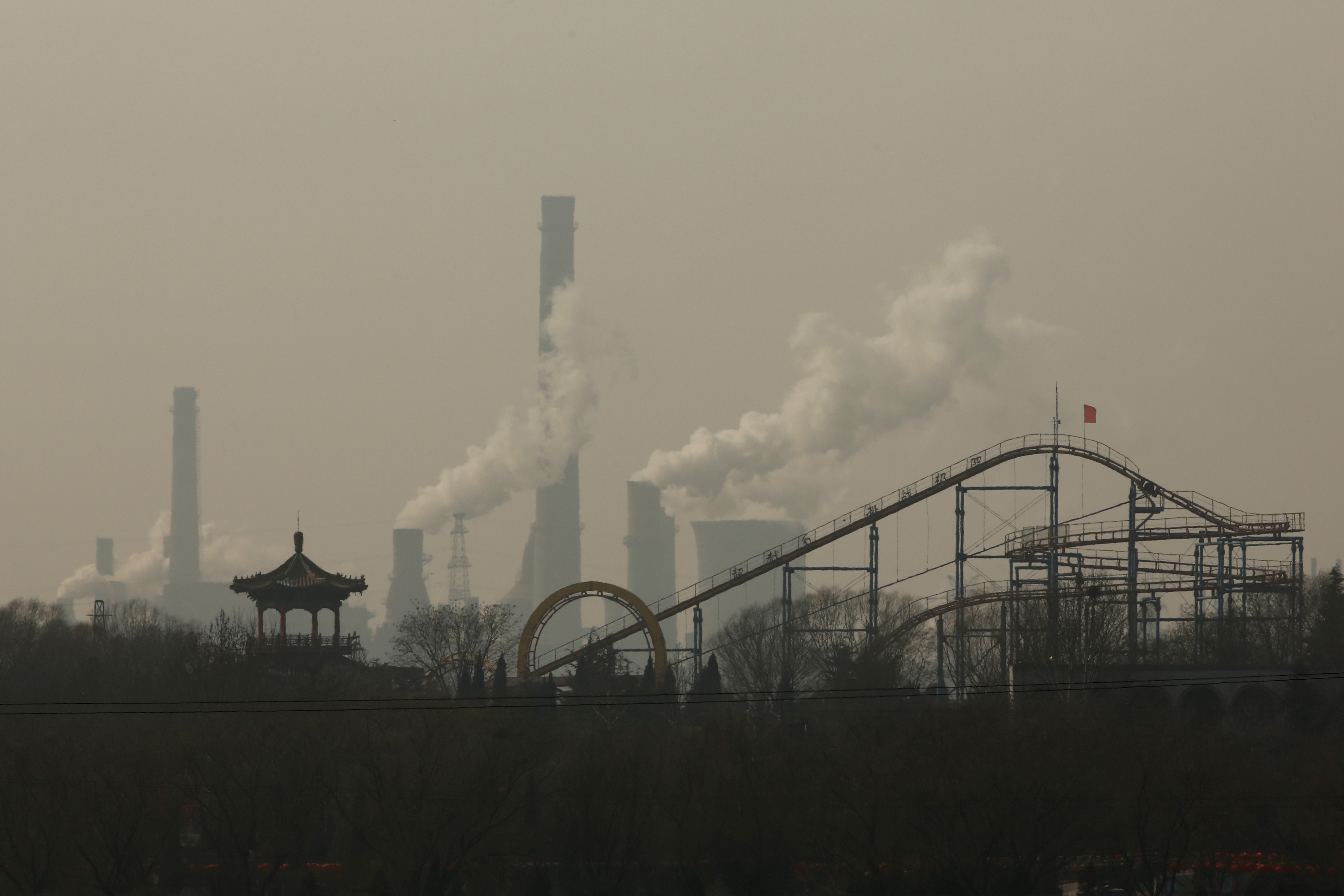 Cooling towers emit steam and chimneys billow in an industrial zone in Wu'an
