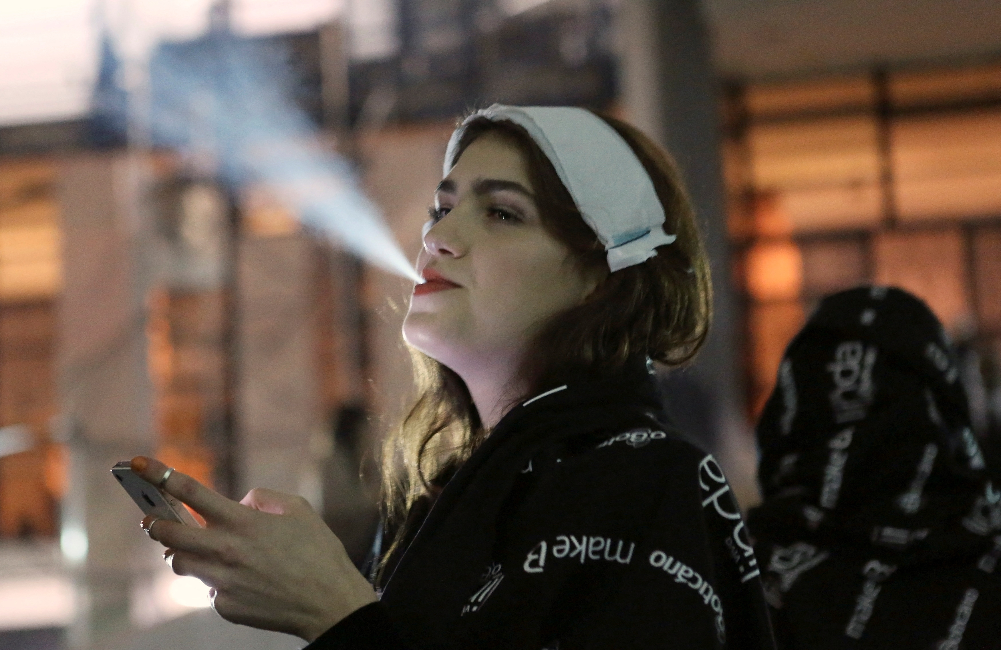 A model smokes a cigarette during Sao Paulo Fashion Week
