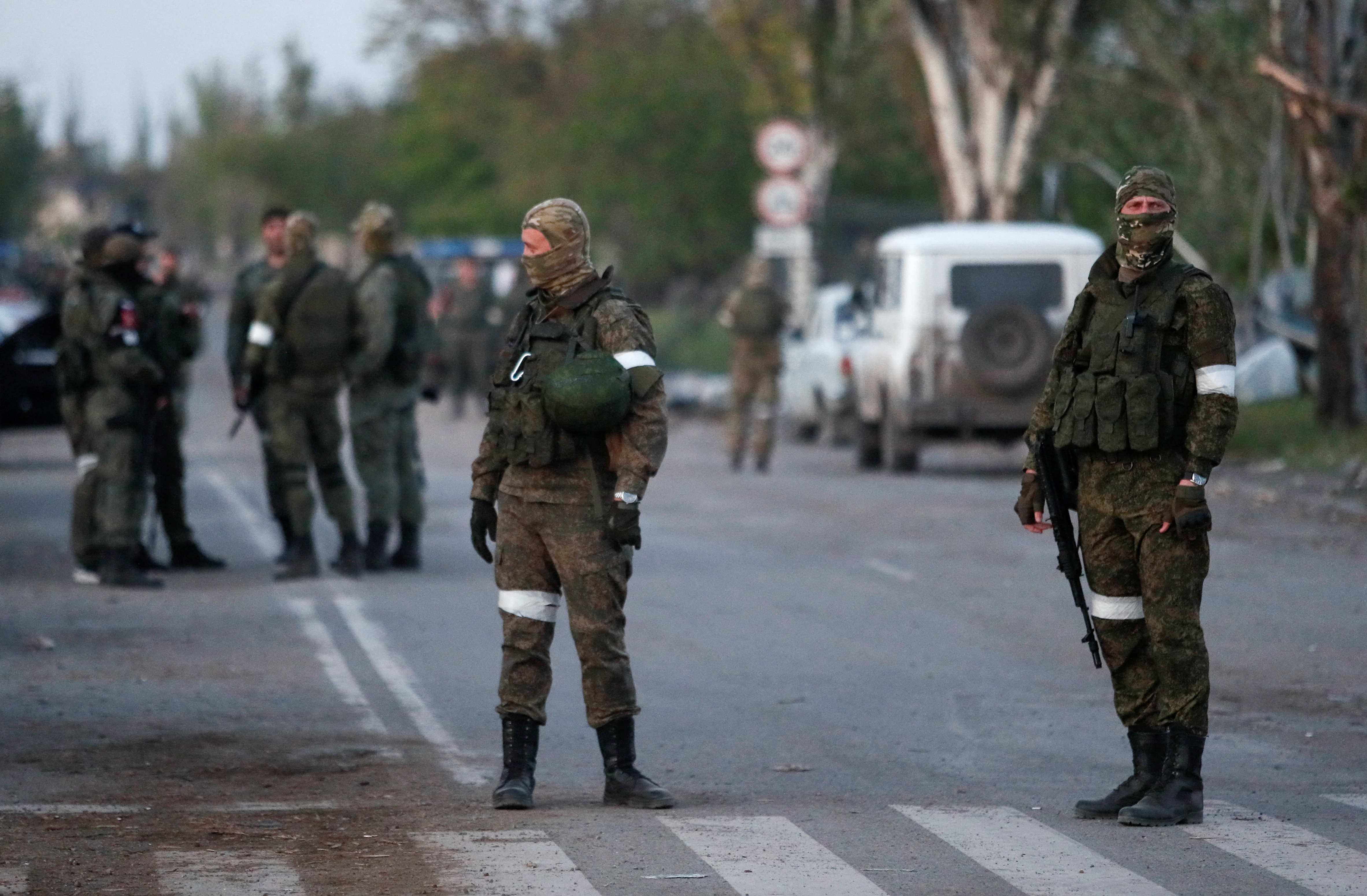 Service members of pro-Russian troops stand guard in Mariupol