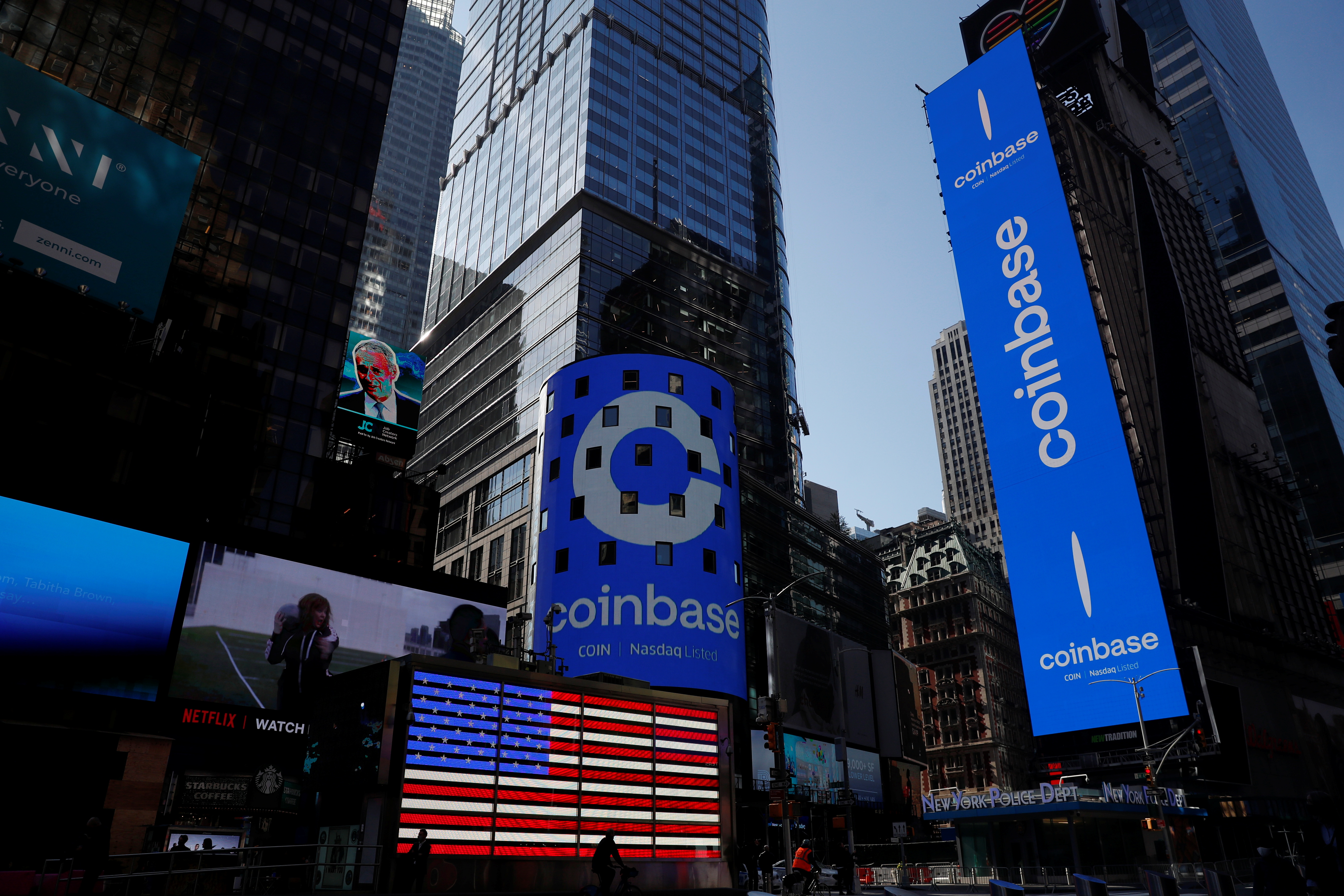 The logo for Coinbase Global Inc is displayed on the Nasdaq MarketSite jumbotron and others at Times Square in New York