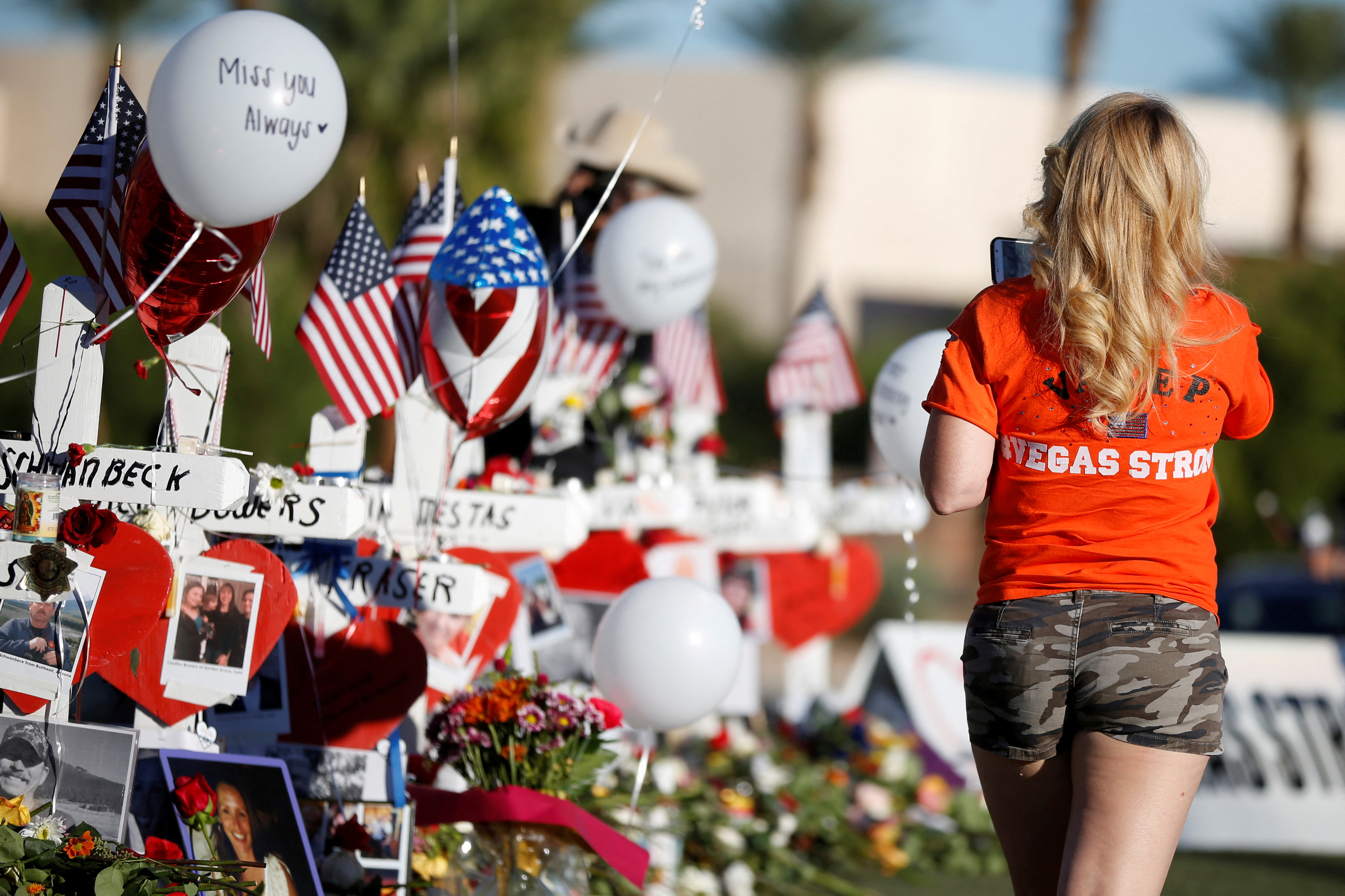 A woman looks at white crosses set up for the victims of the Route 91 Harvest music festival mass shooting in Las Vegas