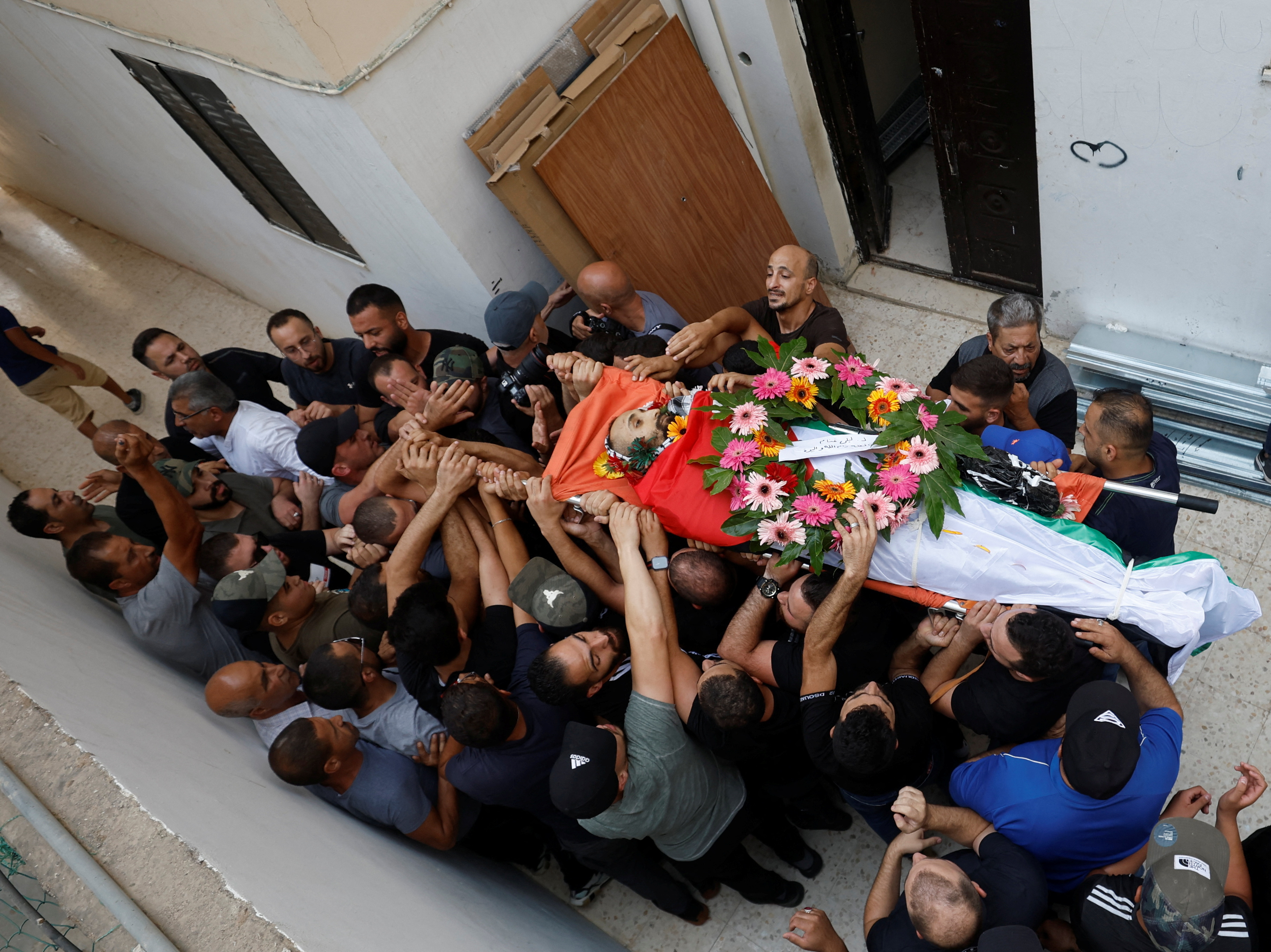 People react after Palestinian Yazan Afanah was killed during an Israeli raid in Qalandiya