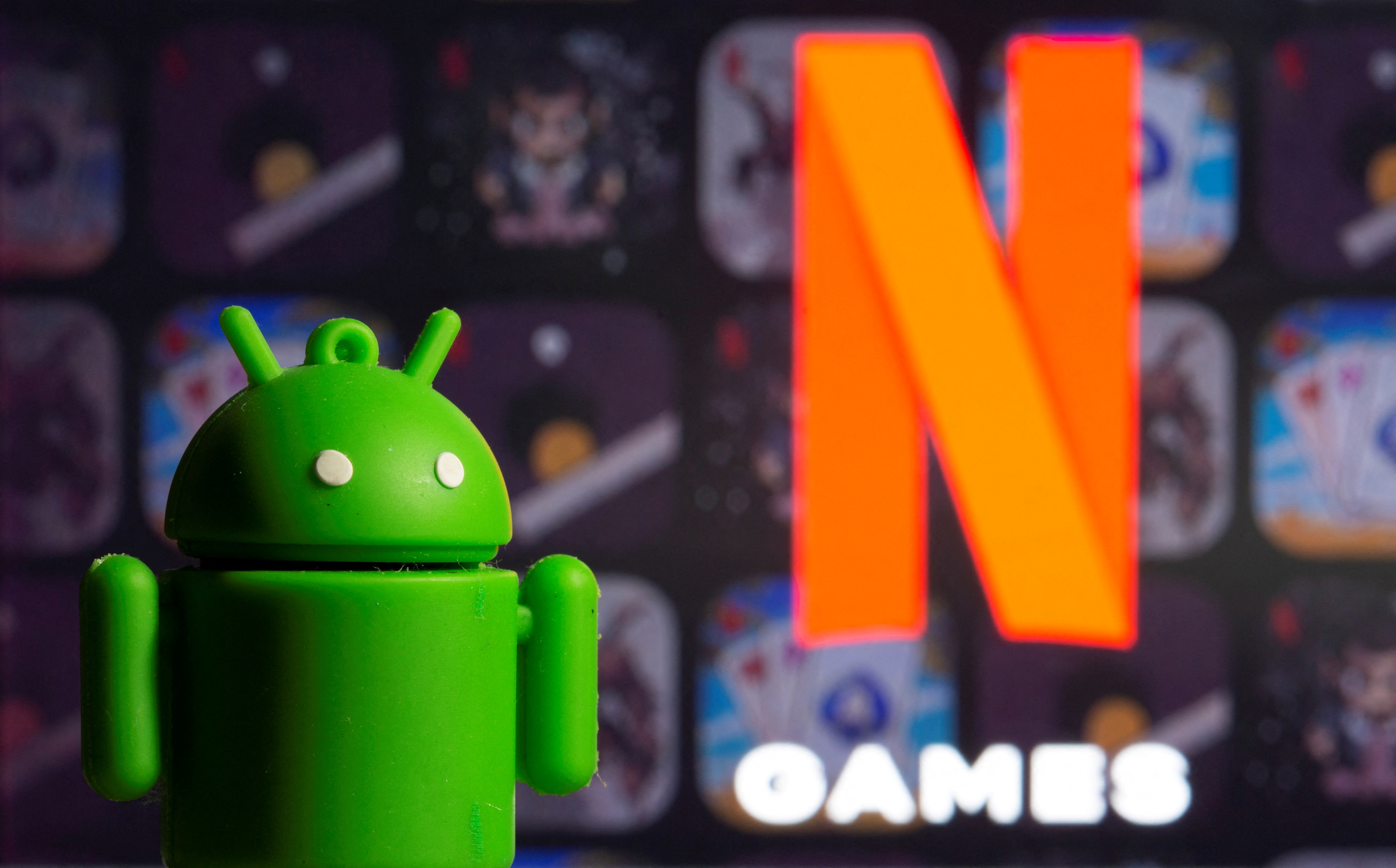 A 3D-printed Android mascot Bugdroid is seen in front of the Netflix Games logo in this illustration