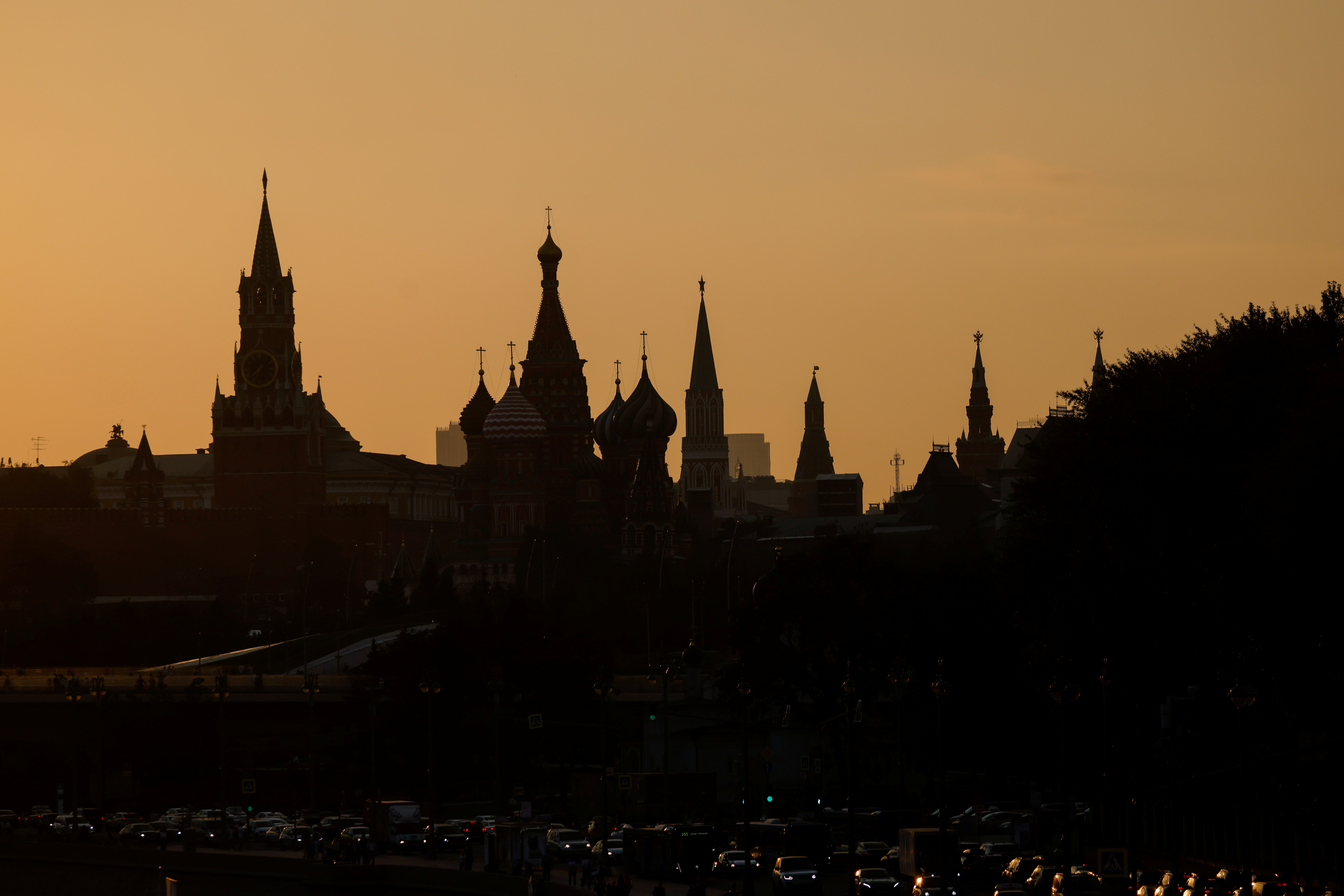 St. Basil's Cathedral and towers of Kremlin are silhouetted against the sunset in Moscow