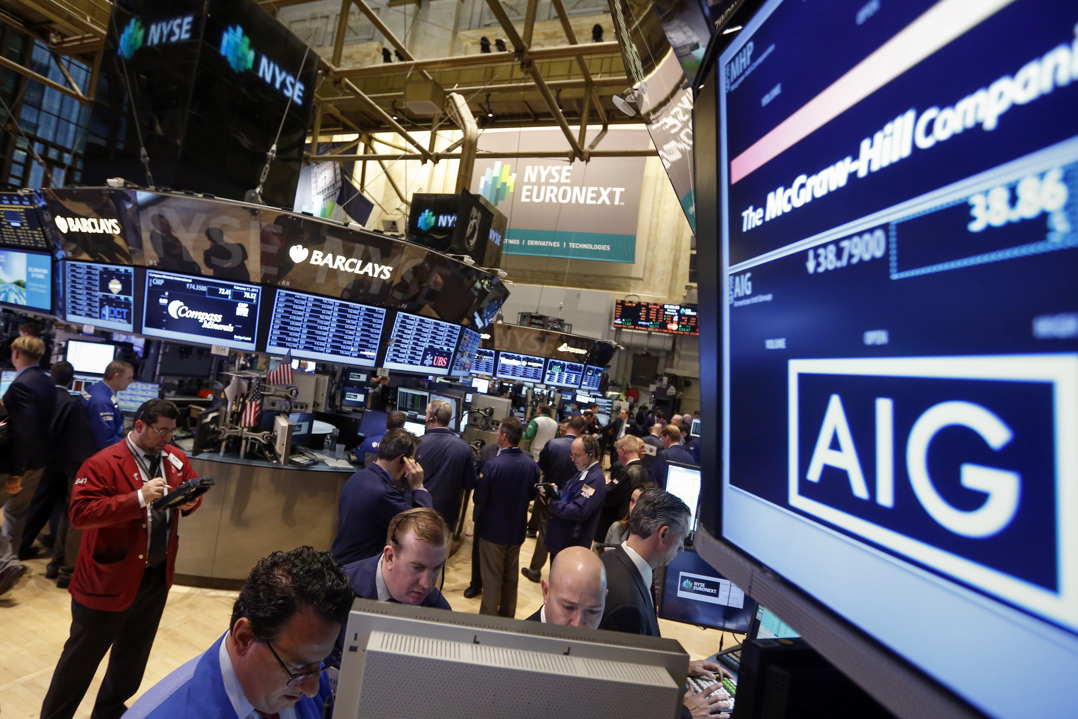 The American International Group, Inc. (AIG) stock ticker is seen on a monitor as traders work on the floor of the New York Stock Exchange