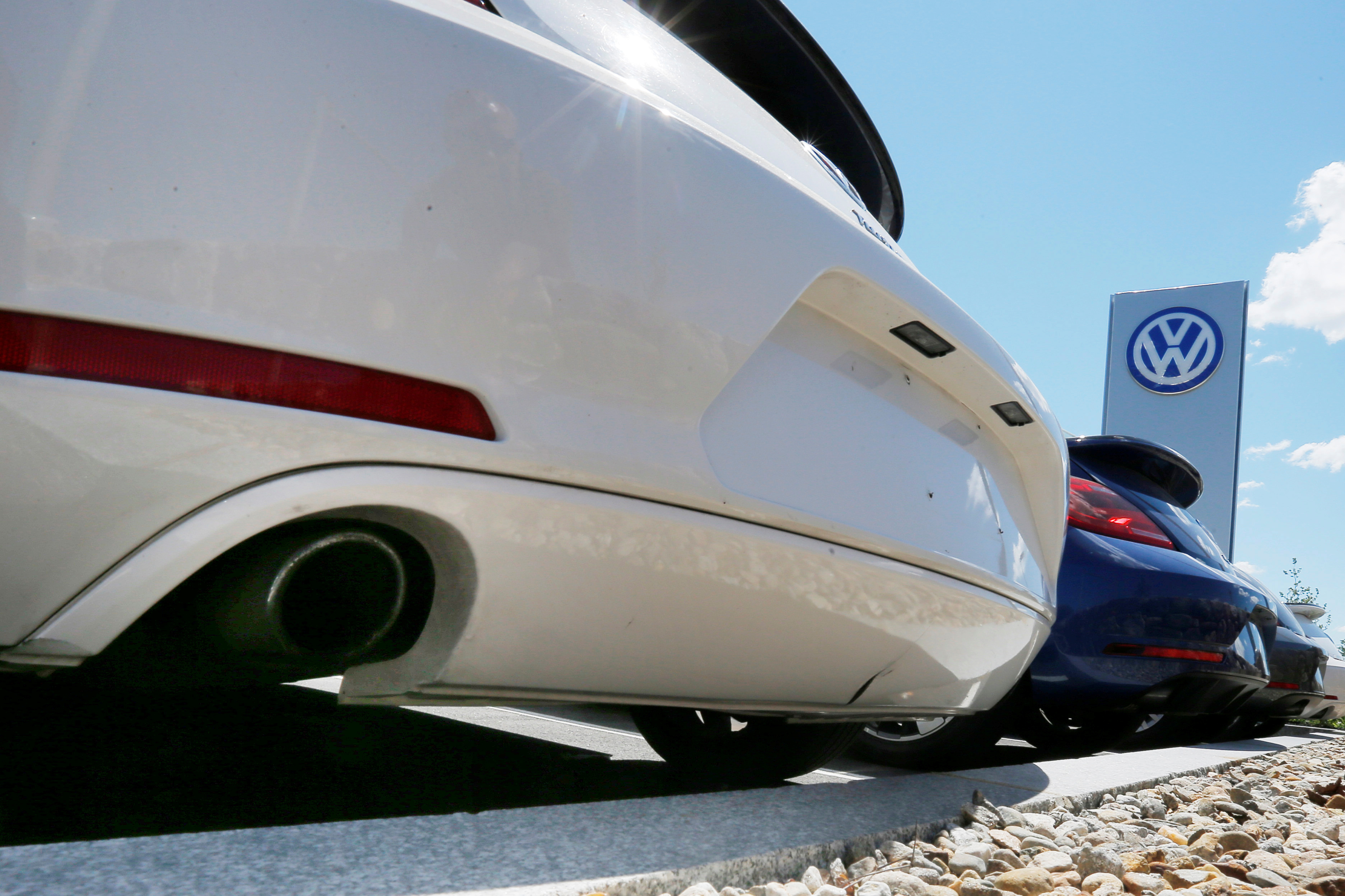 New Volkswagen vehicles are parked with their exhaust pipes facing the street at a dealership in Medford