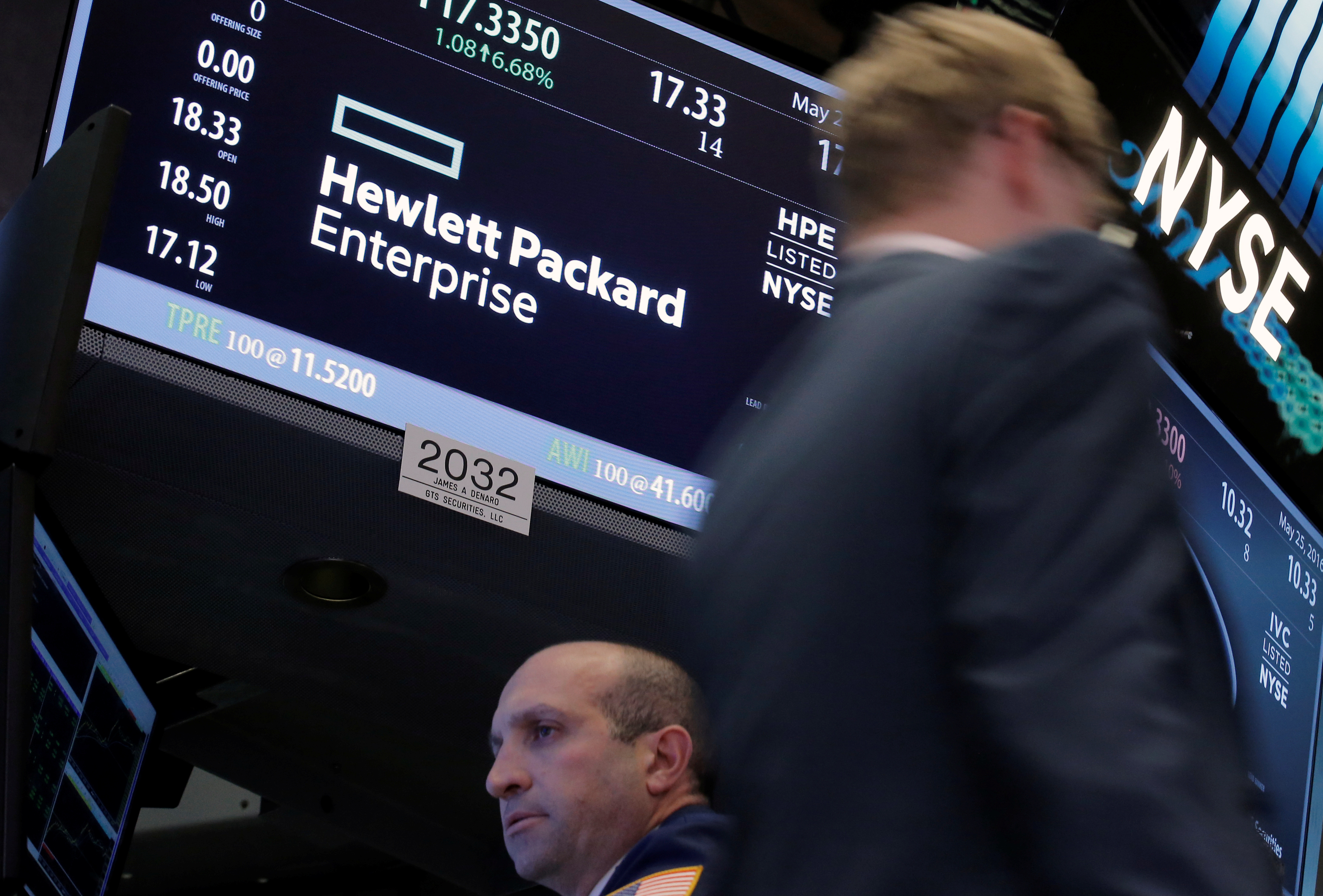 A trader passes by the post where Hewlett Packard Enterprise Co., is traded on the floor of the New York Stock Exchange