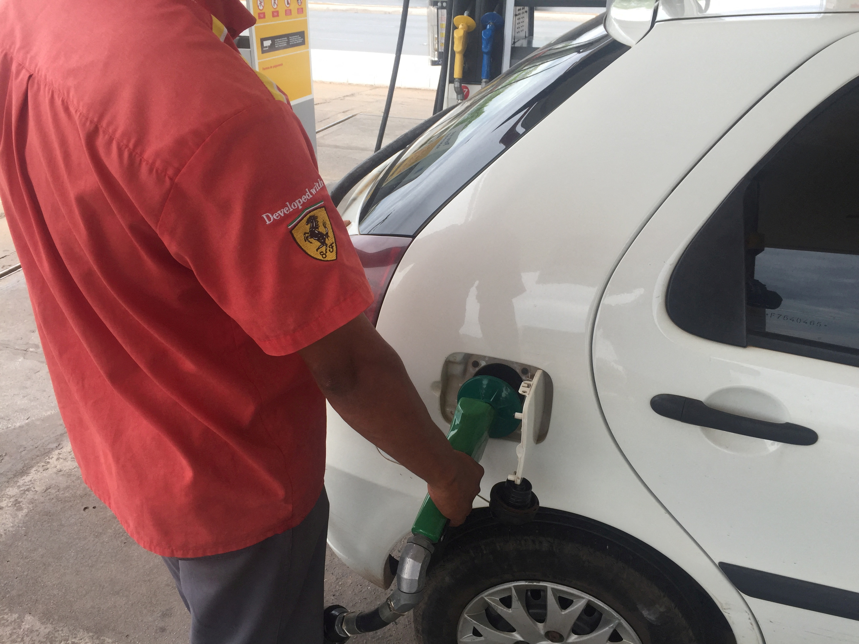 A gas station worker fills up a car's tank with ethanol in Cuiaba
