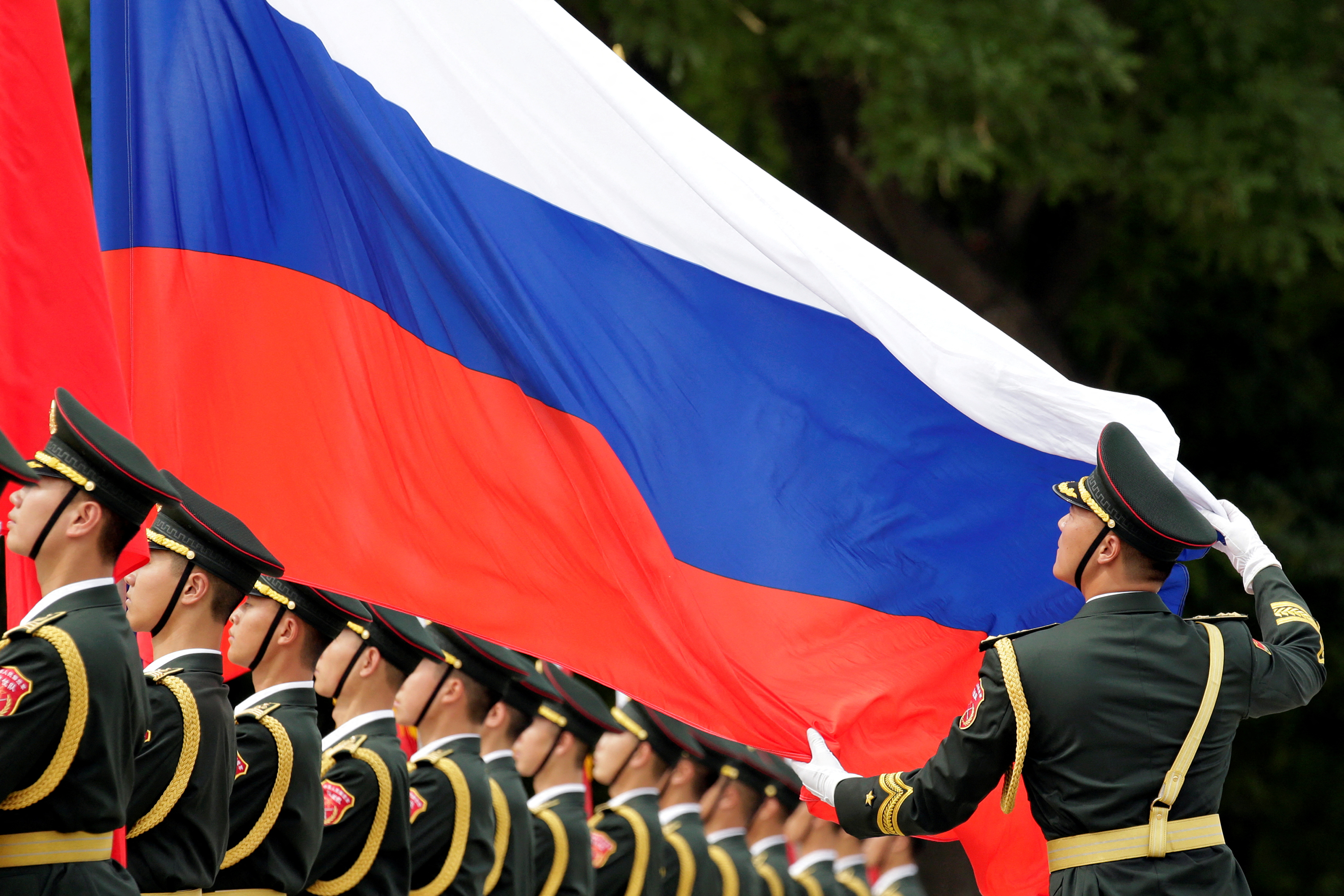 An honour guard holds a Russia flag during preparations for a welcome ceremony for Russian President Vladimir Putin outside the Great Hall of the People in Beijing, China