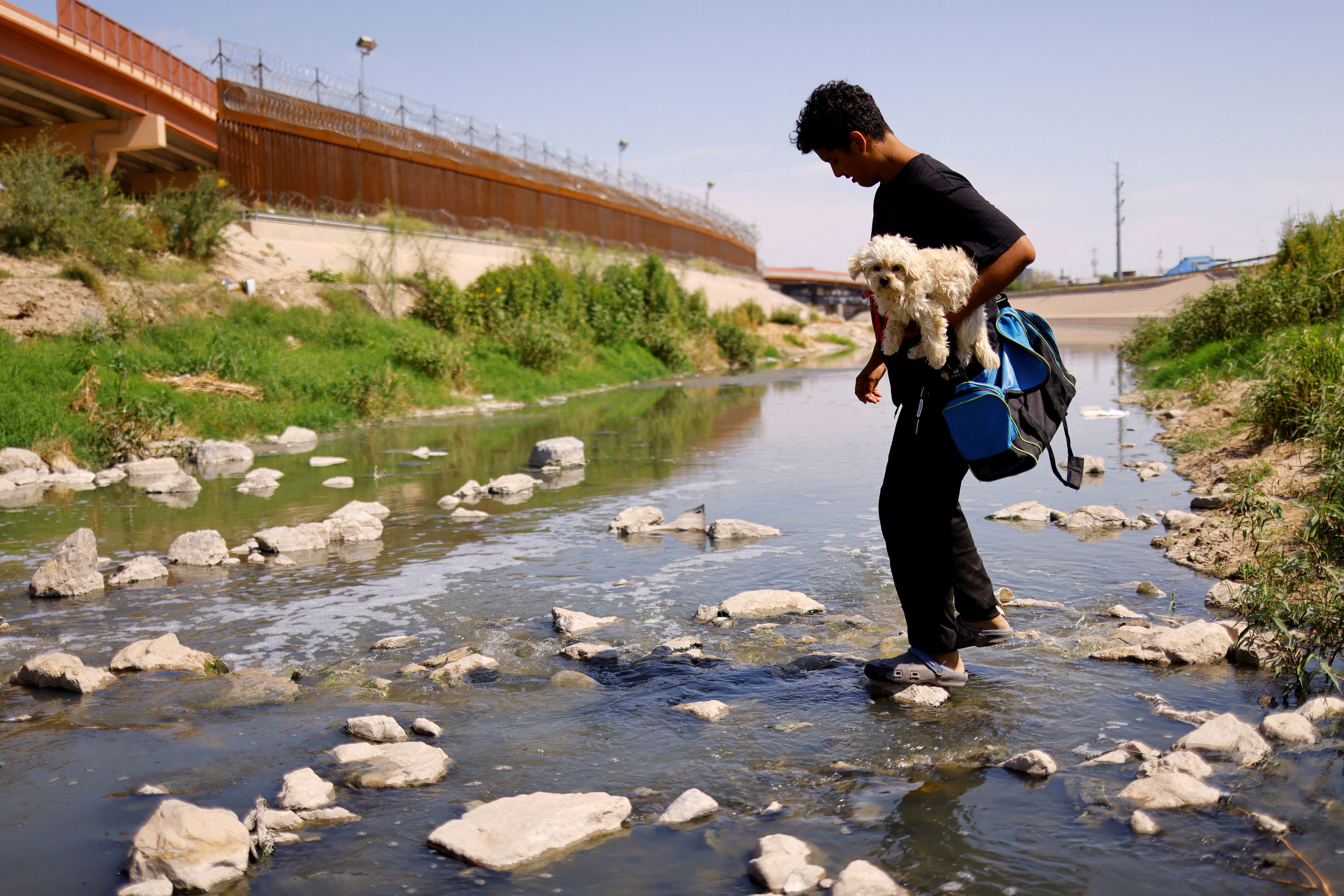 Asylum-seeking migrants cross the Rio Bravo river in Ciudad Juarez