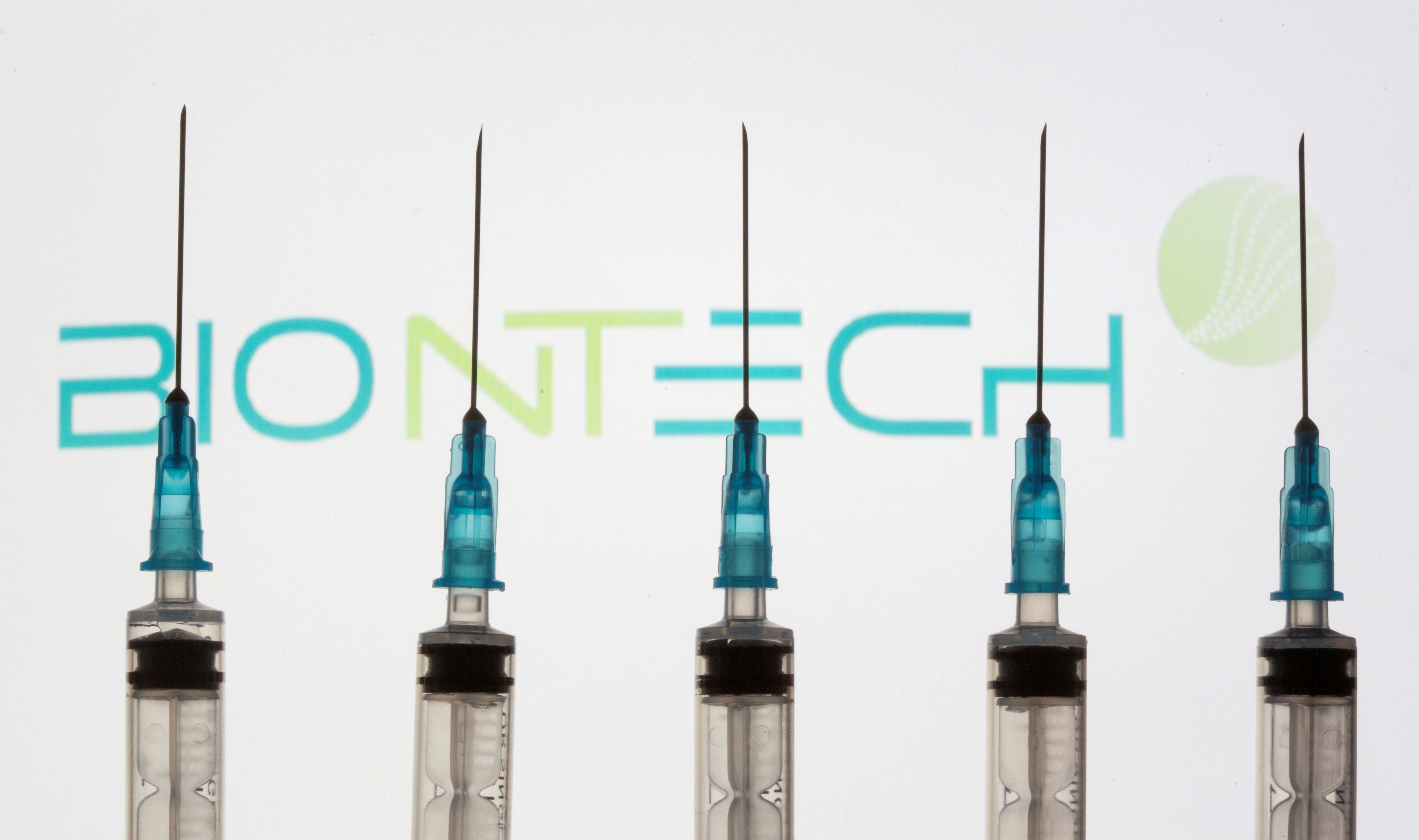 Syringes are seen in front of a displayed Biontech logo in this illustration taken November 10, 2020. REUTERS/Dado Ruvic