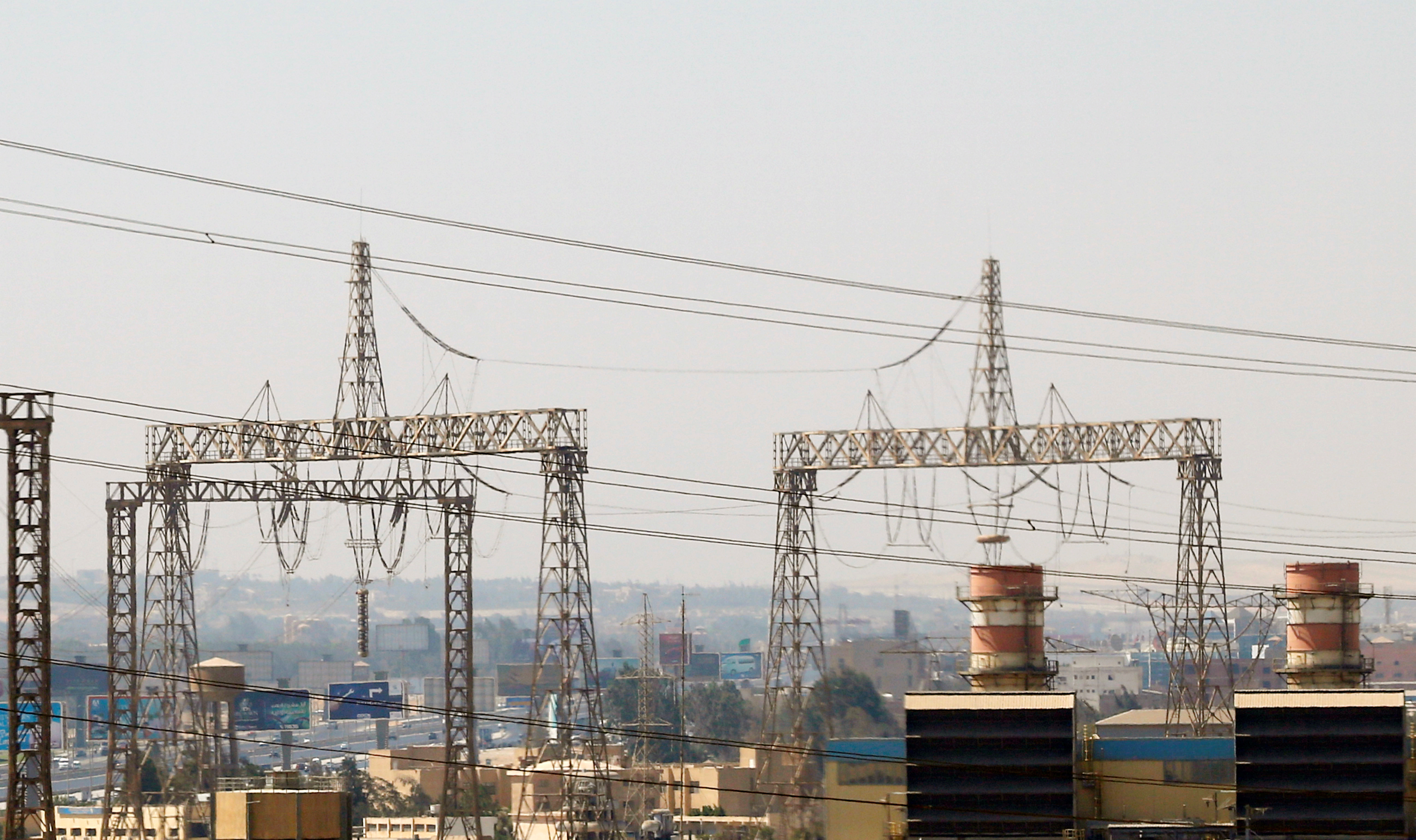 Electricity pylons and power transmission lines are seen along a road in Cairo