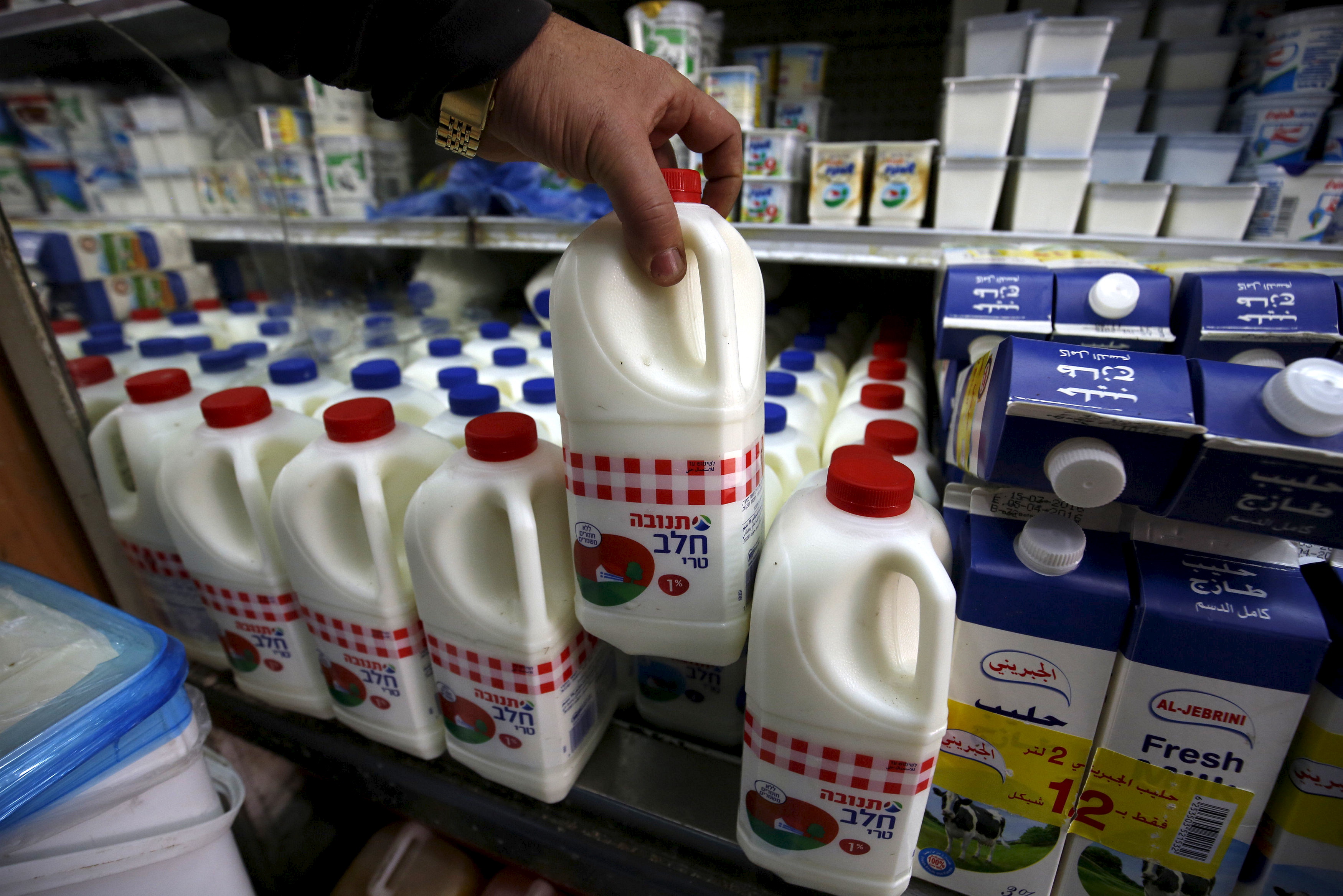 Man shows a bottle of milk produced by Israeli food-maker Tnuva at a supermarket in the West Bank city of Ramallah