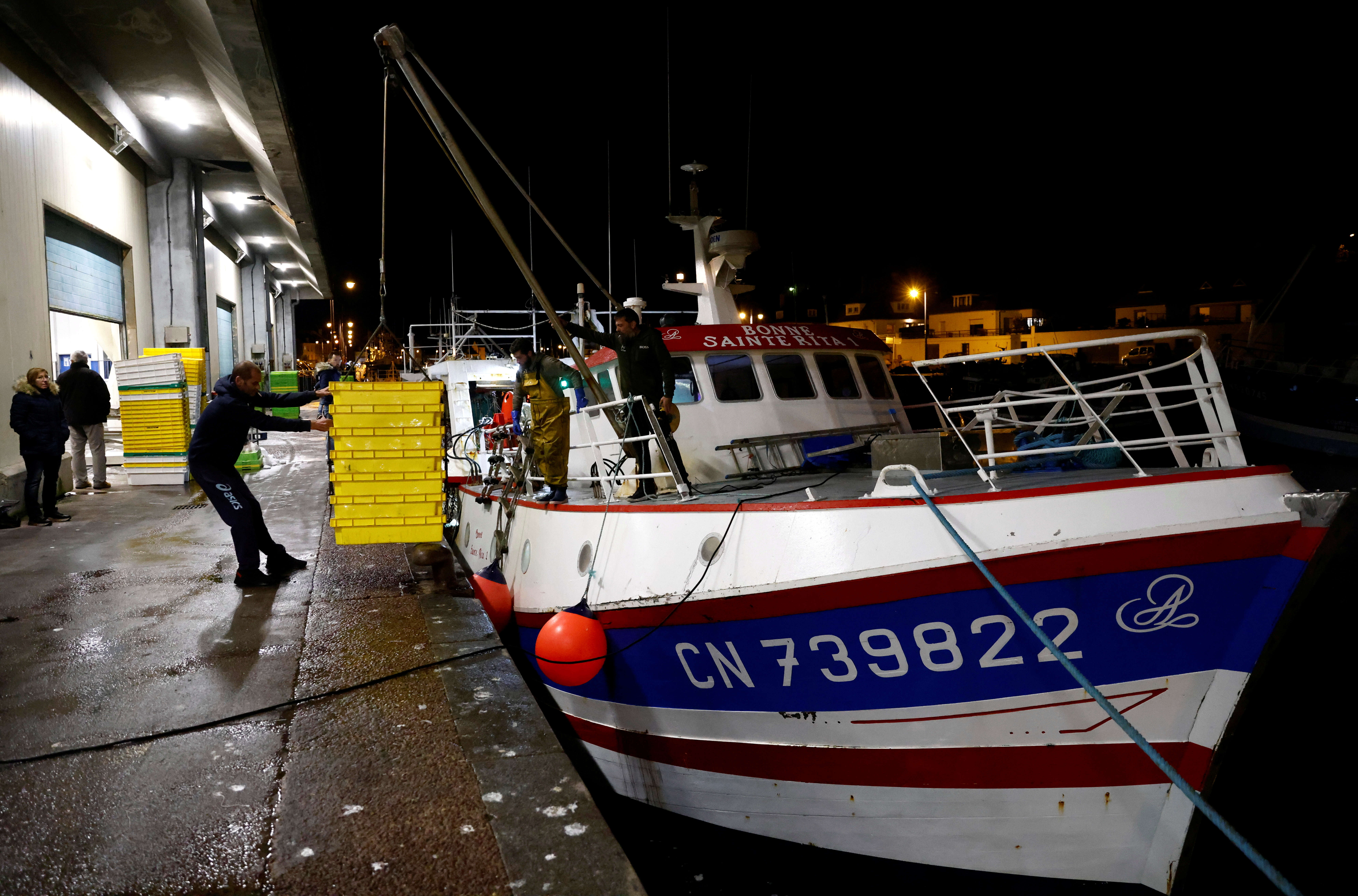 Fishermen unload box of fish at the fishing port in Port-en-Bessin-Huppain, France, November 1, 2021. REUTERS/Stephane Mahe