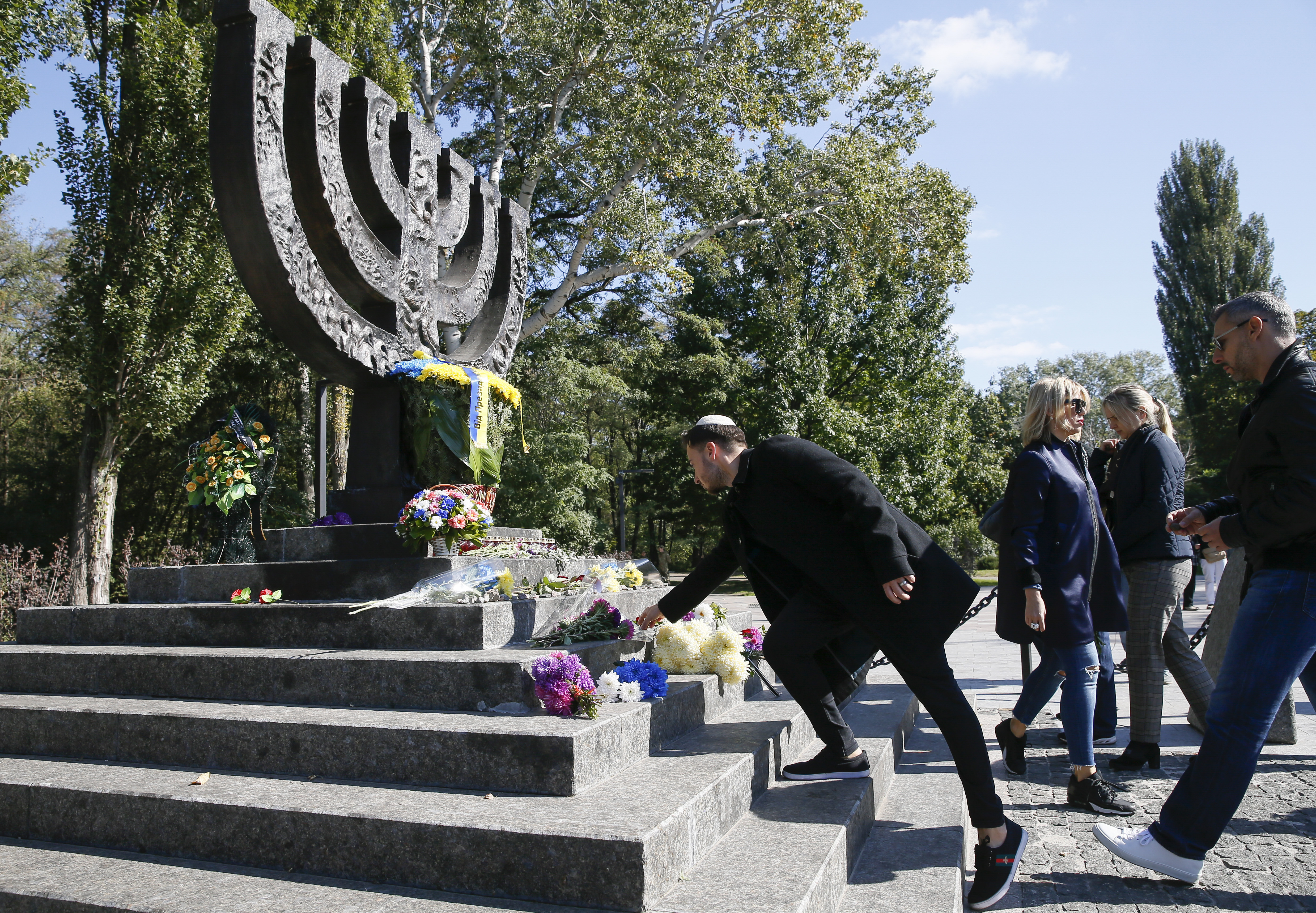 People attend a ceremony at a monument commemorating the victims of Babyn Yar in Kiev